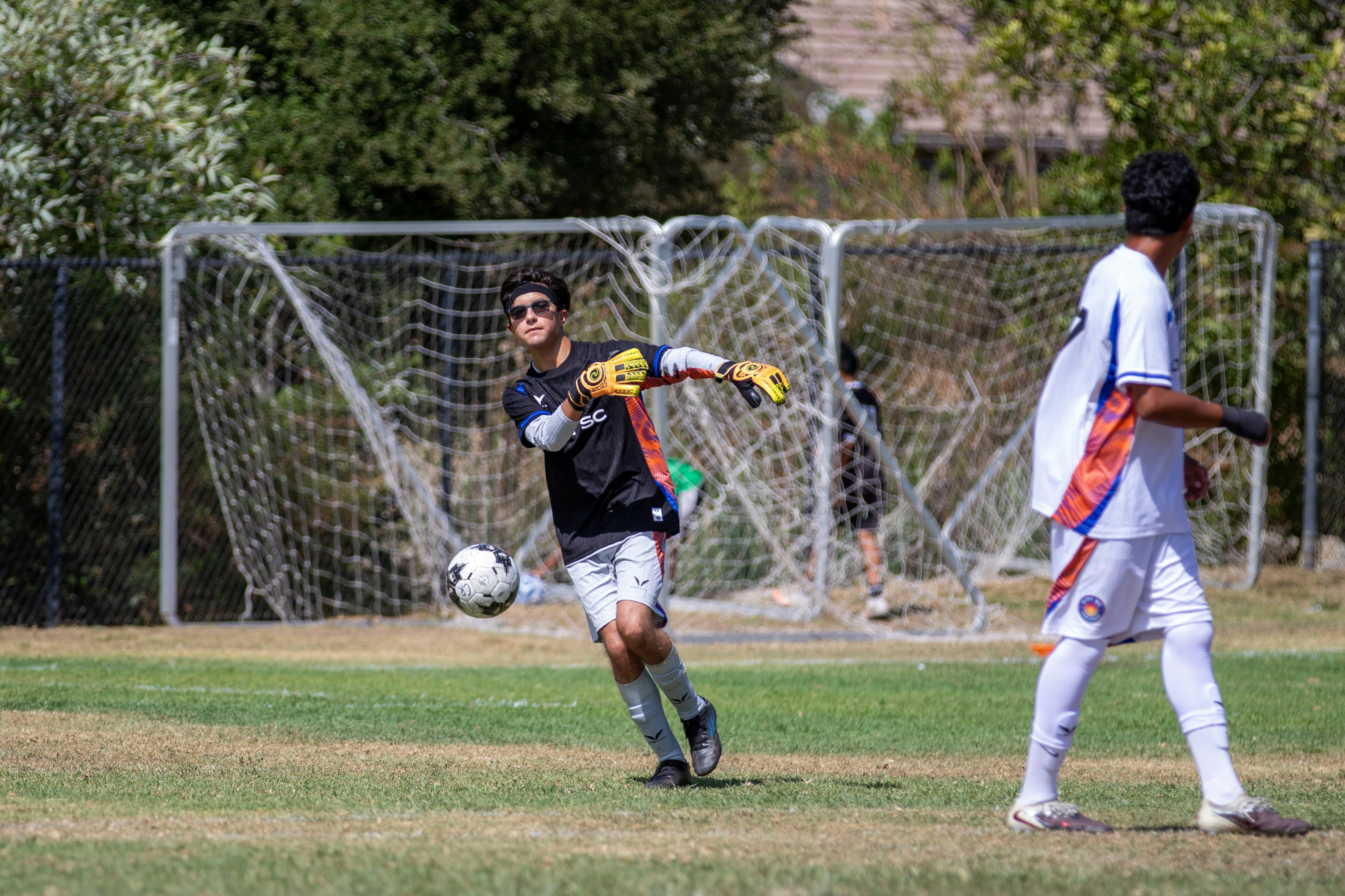 A soccer goalie reaching for the ball during a game