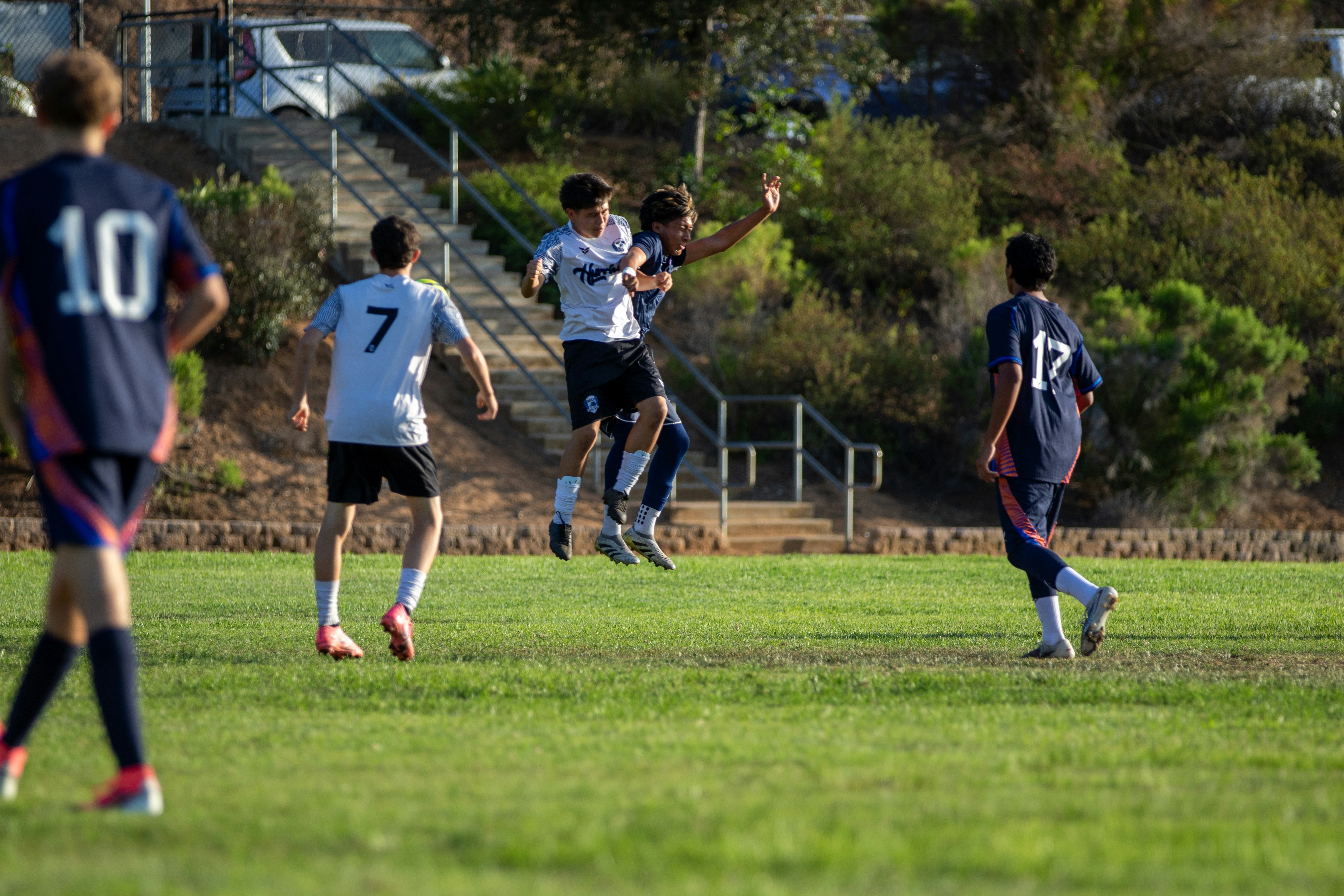 Two soccer players jump for the ball during a game