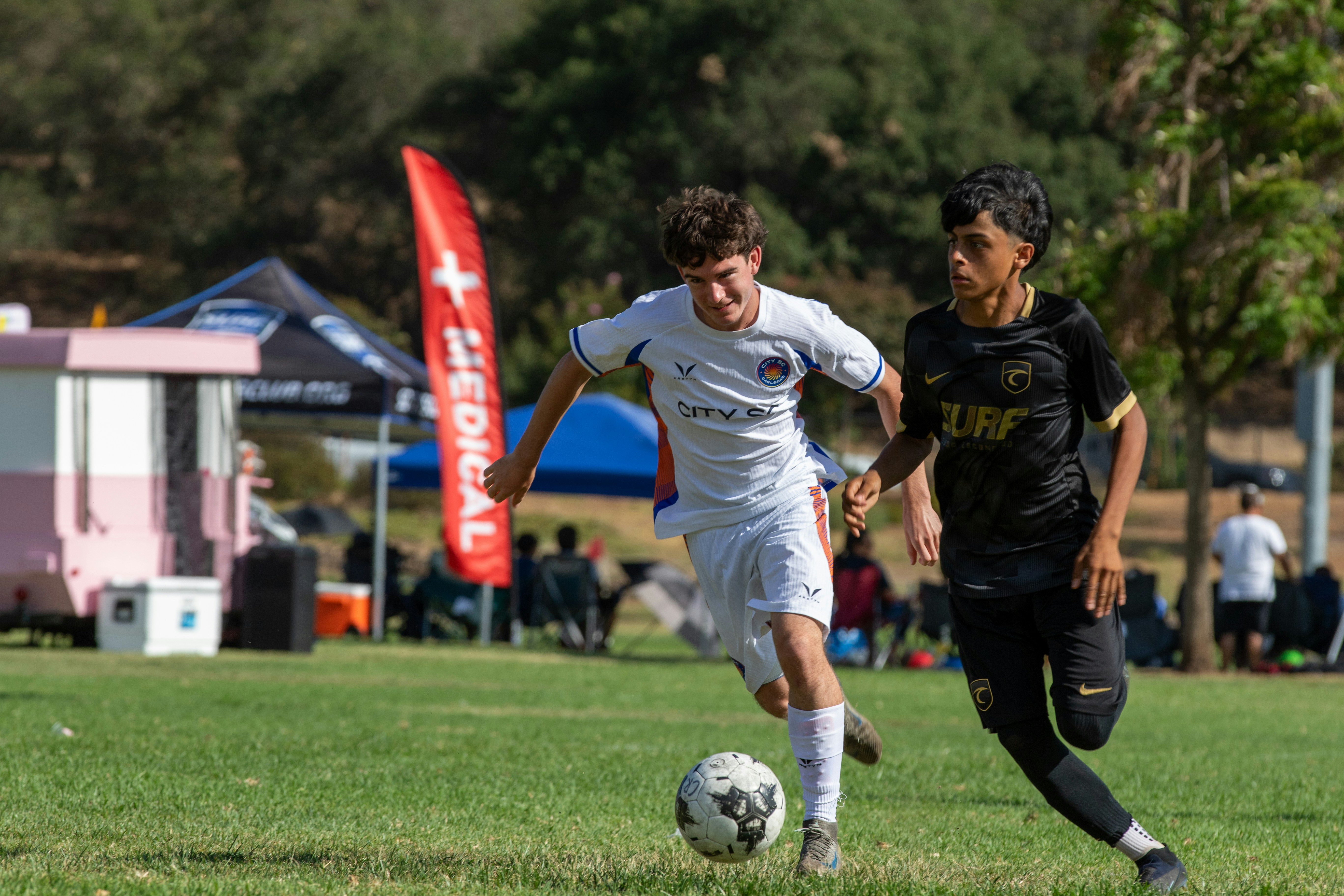 Young soccer players dribbling the ball during a match