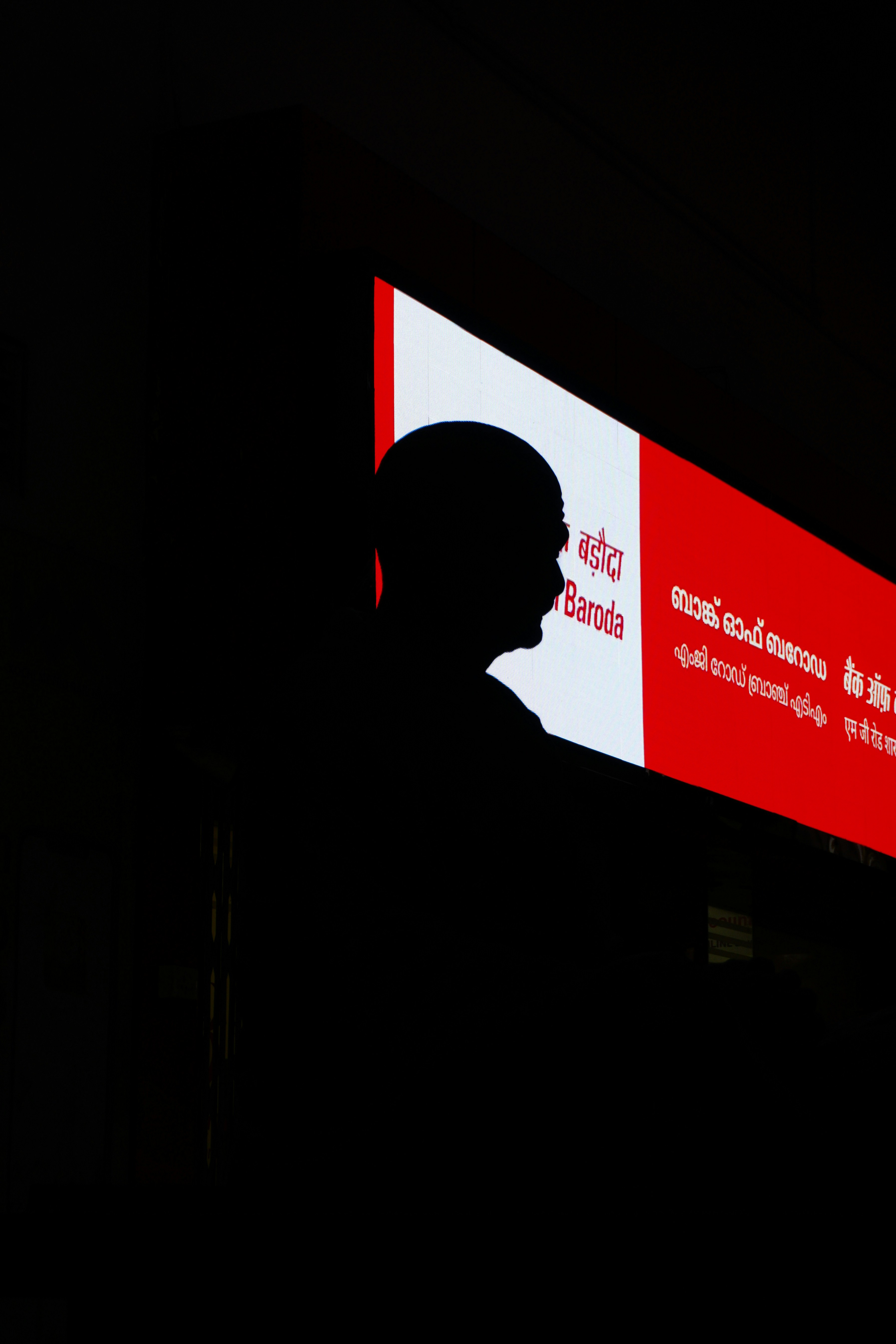 Person's silhouette against a backlit screen with text.