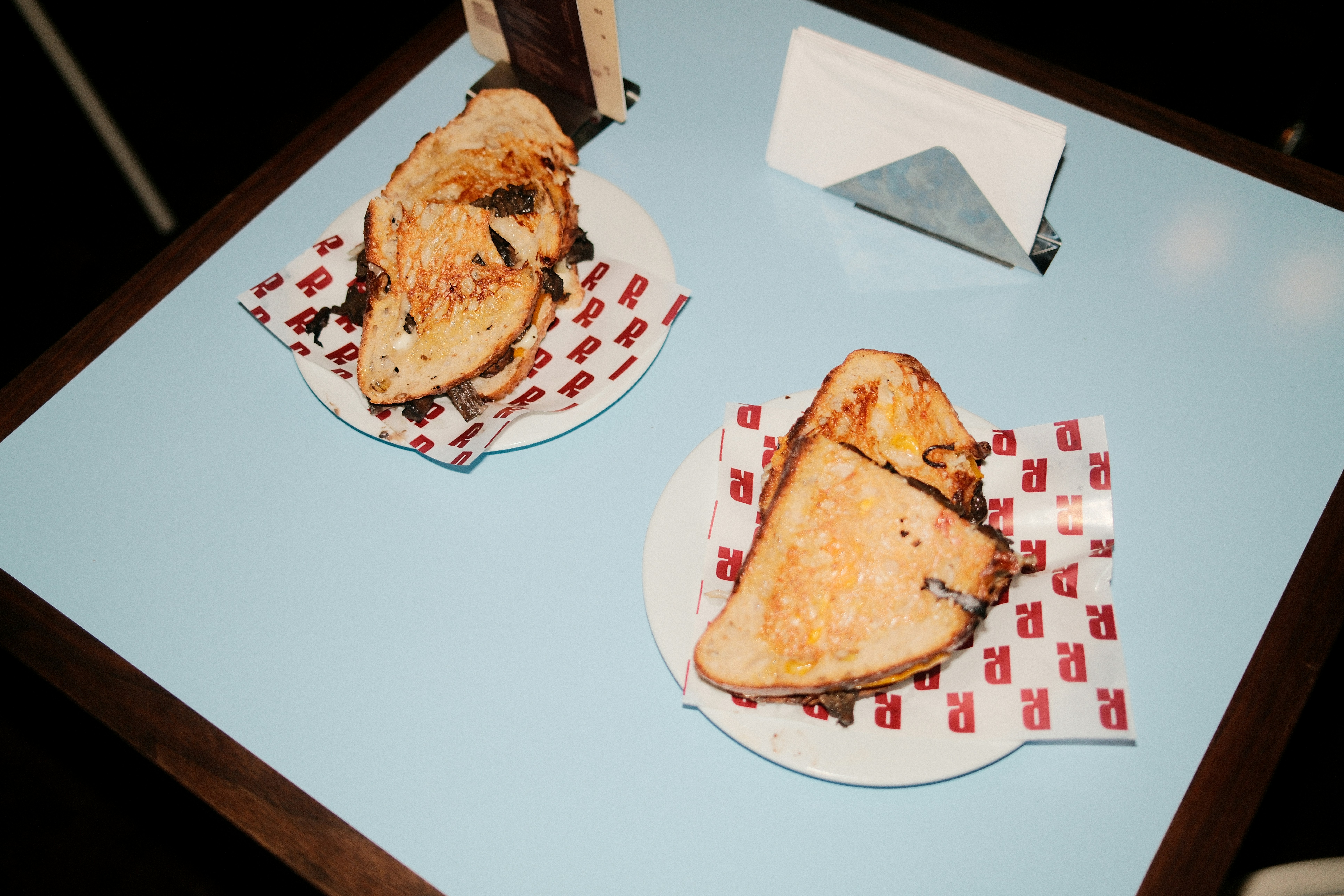 Toasted sandwiches served on a light blue table
