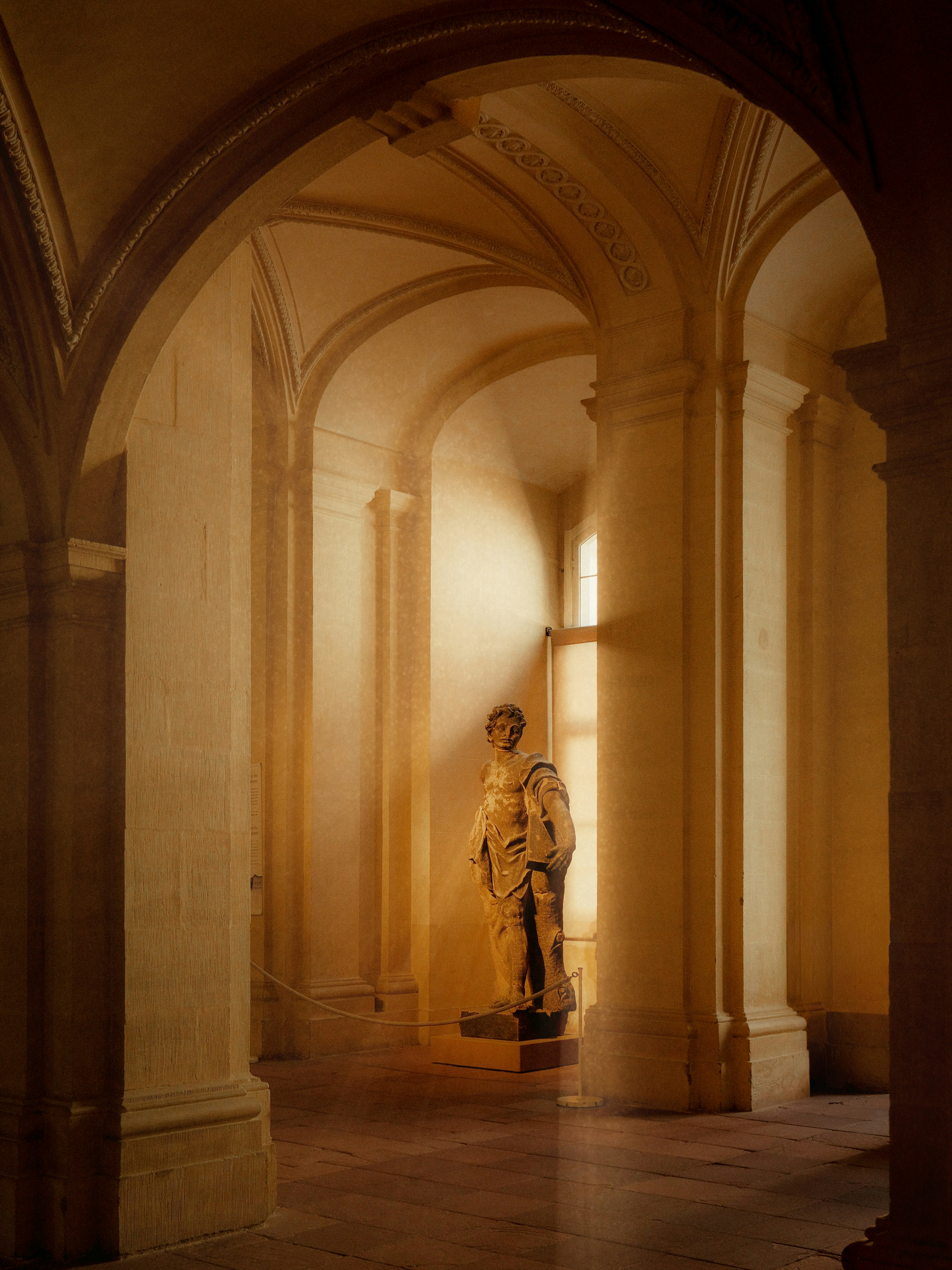Corridoio della residenza di Würzburg con statua classica illuminata dalla luce