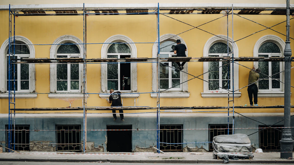 Ouvriers en échafaudage rénovant une façade