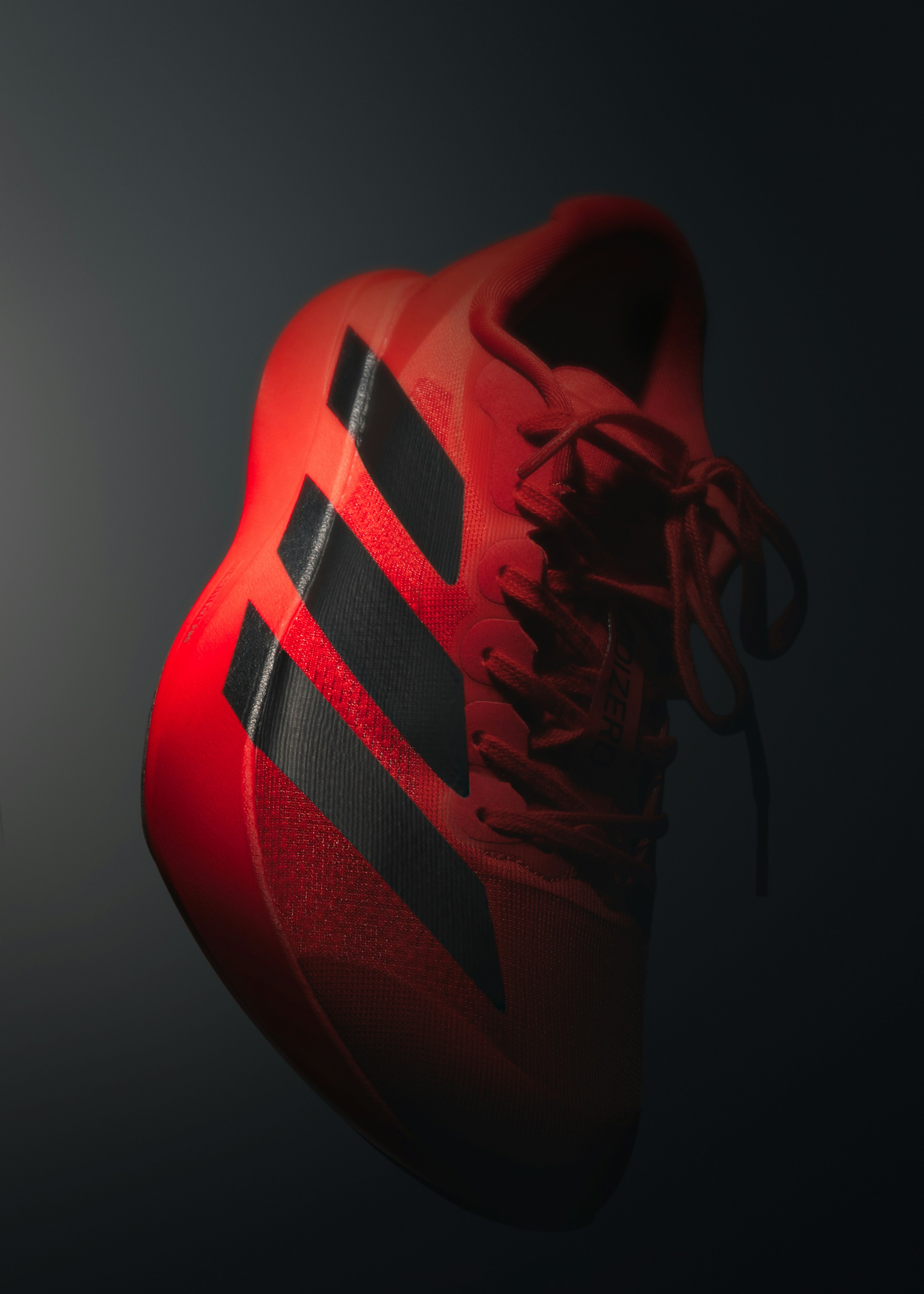 A red and black athletic shoe against a dark background