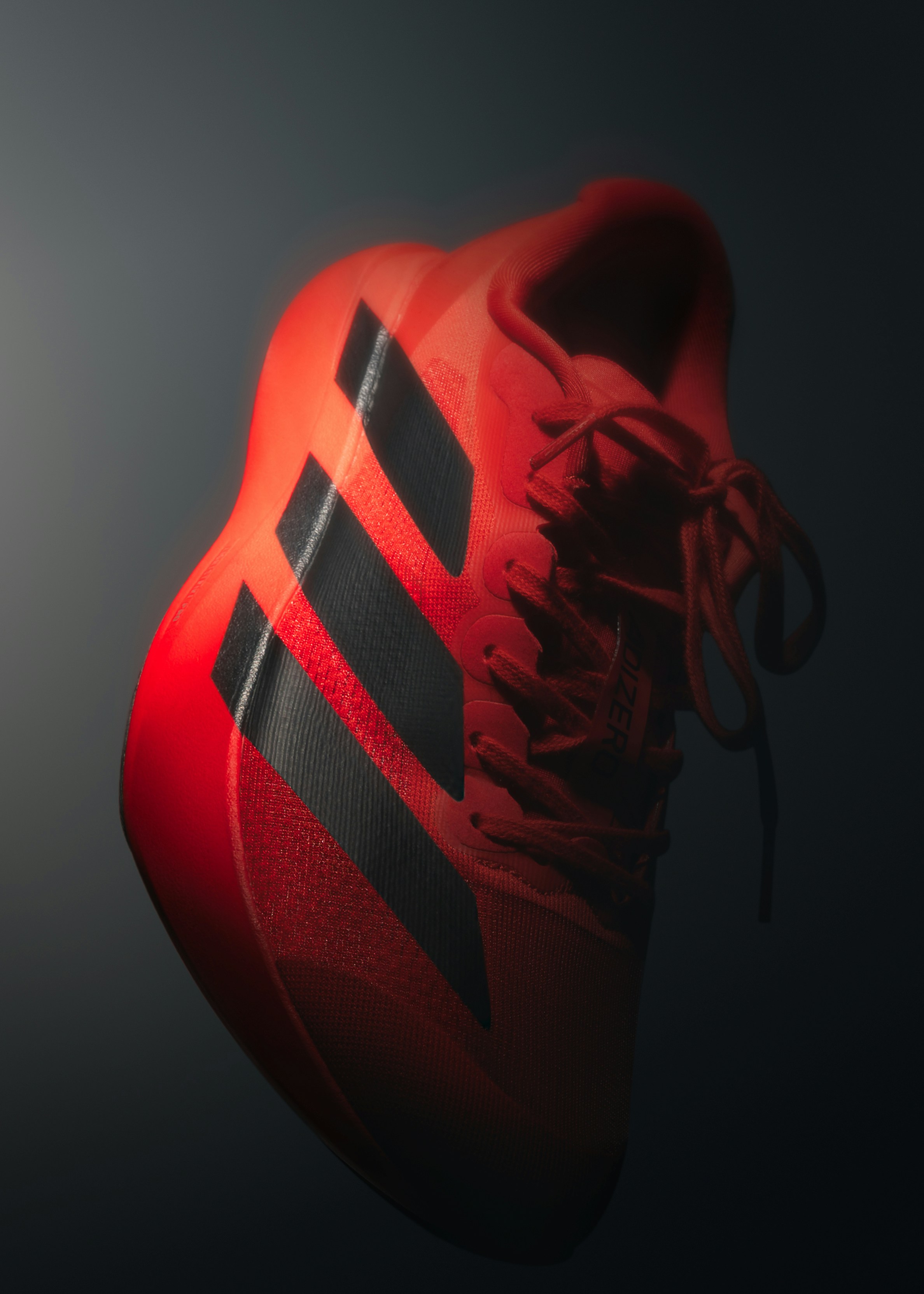 Sepatu atletik merah cerah dengan garis hitam