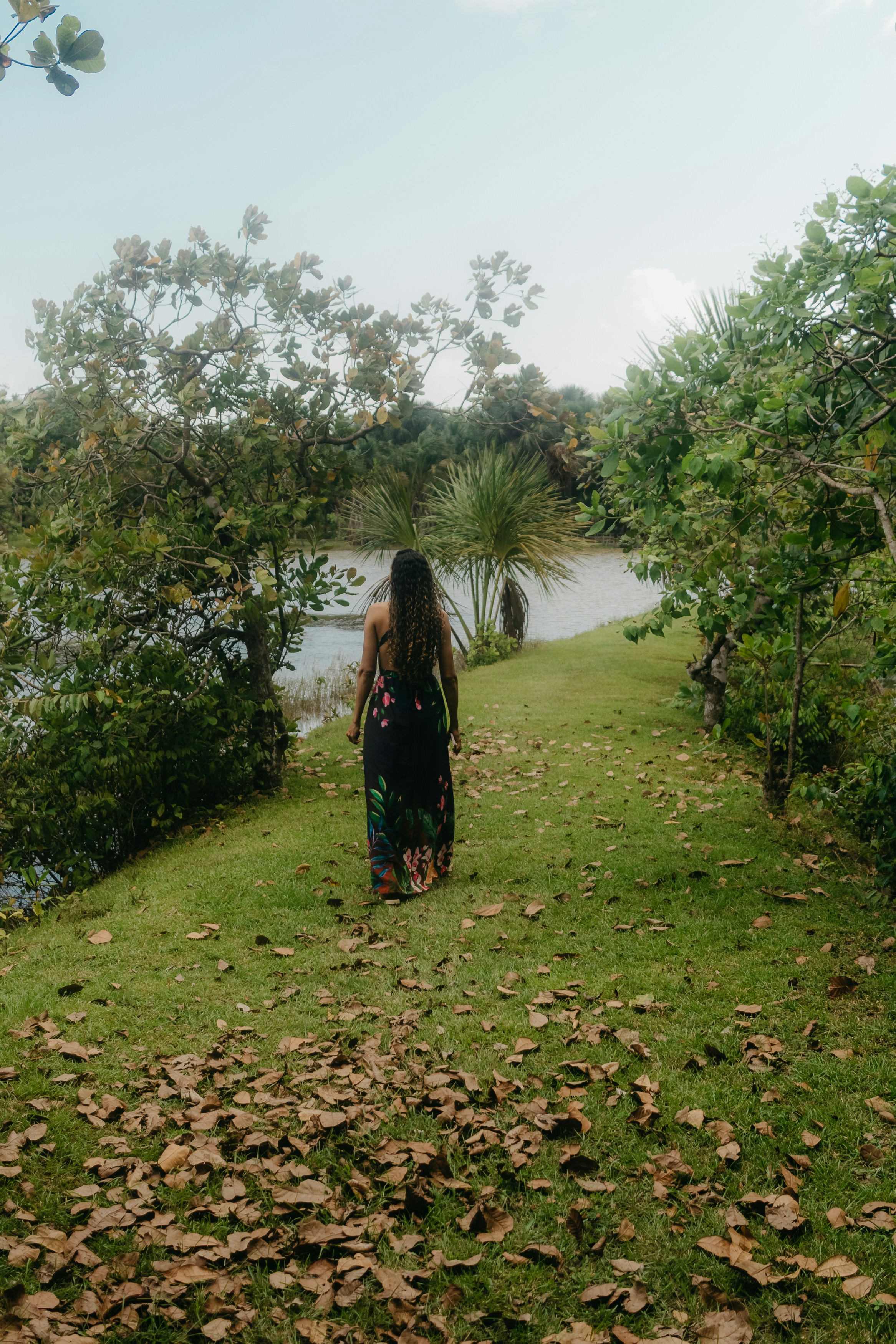 Woman in floral dress walking by a lake