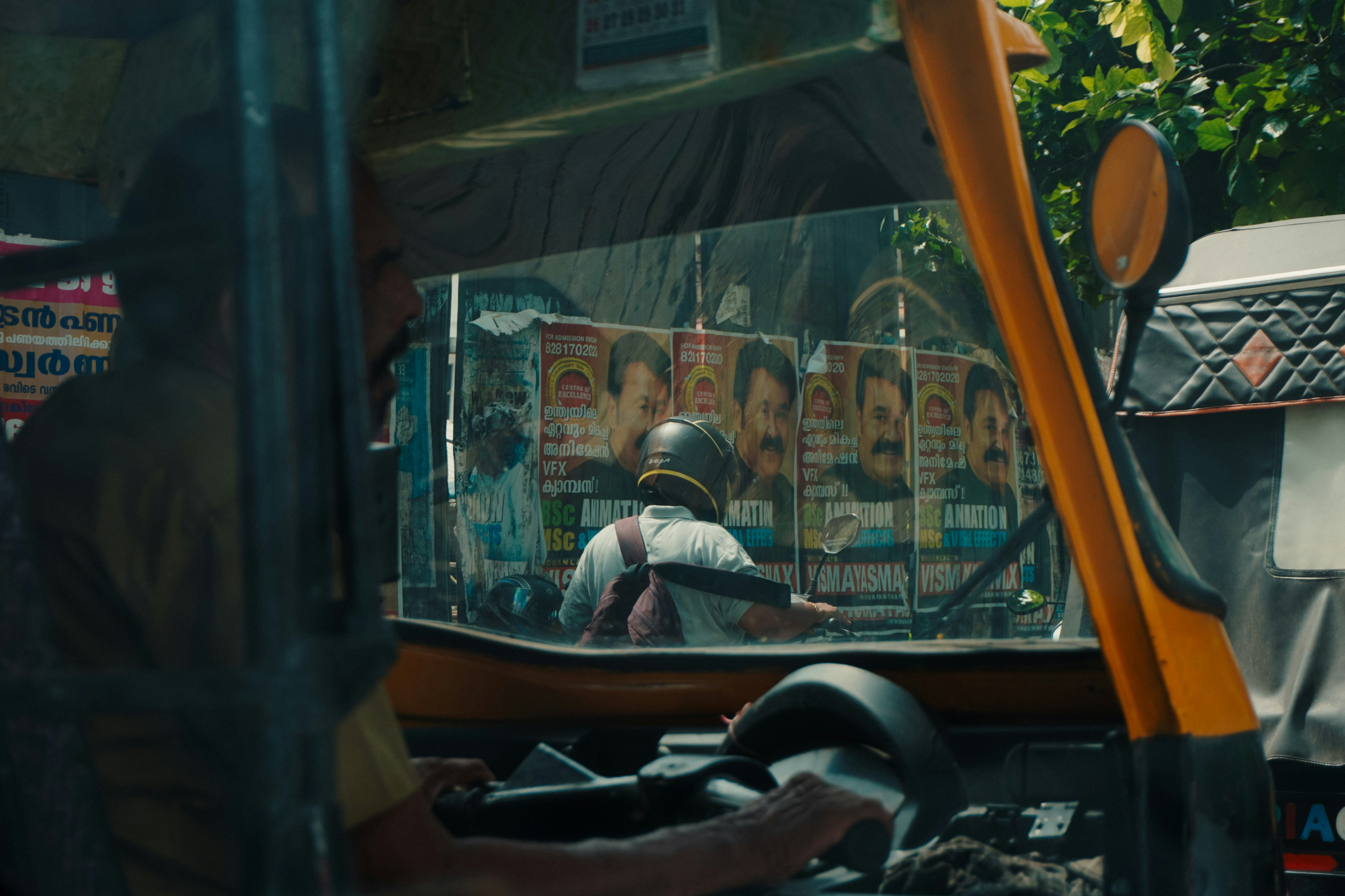 Auto-rickshaw interior looking at another with many posters.