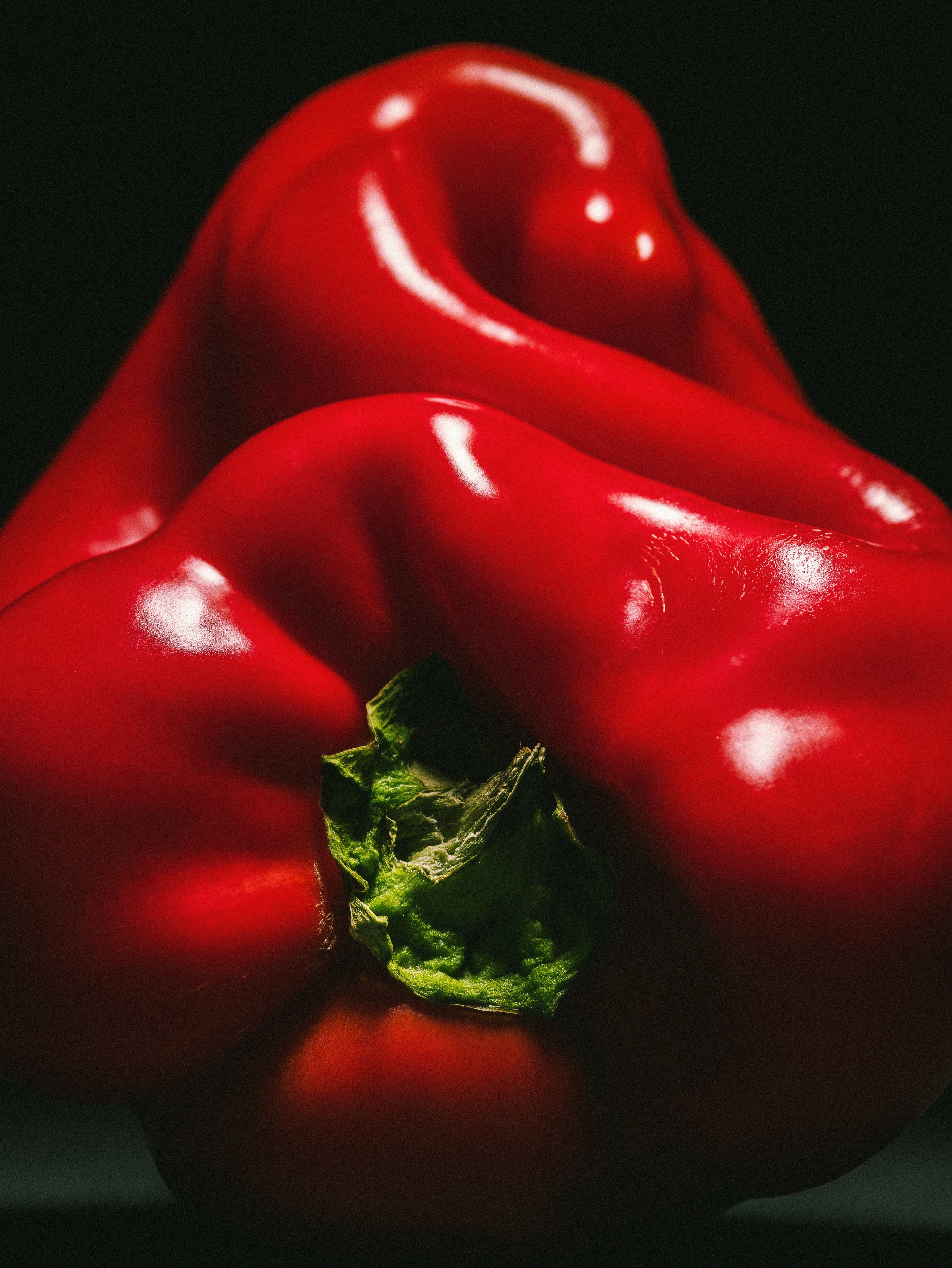 A red bell pepper with a green stem.