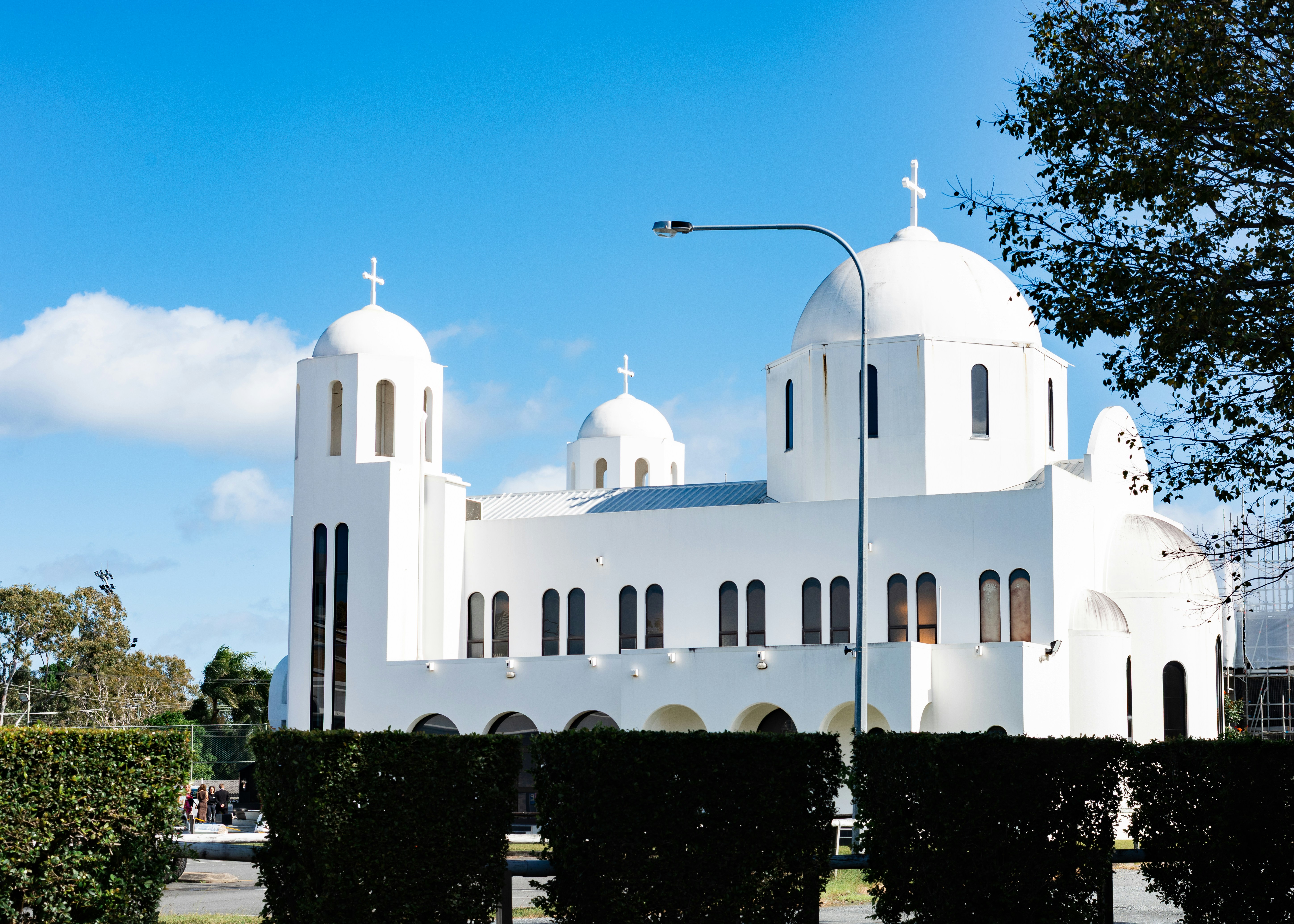 A white domed church stands against a clear blue sky