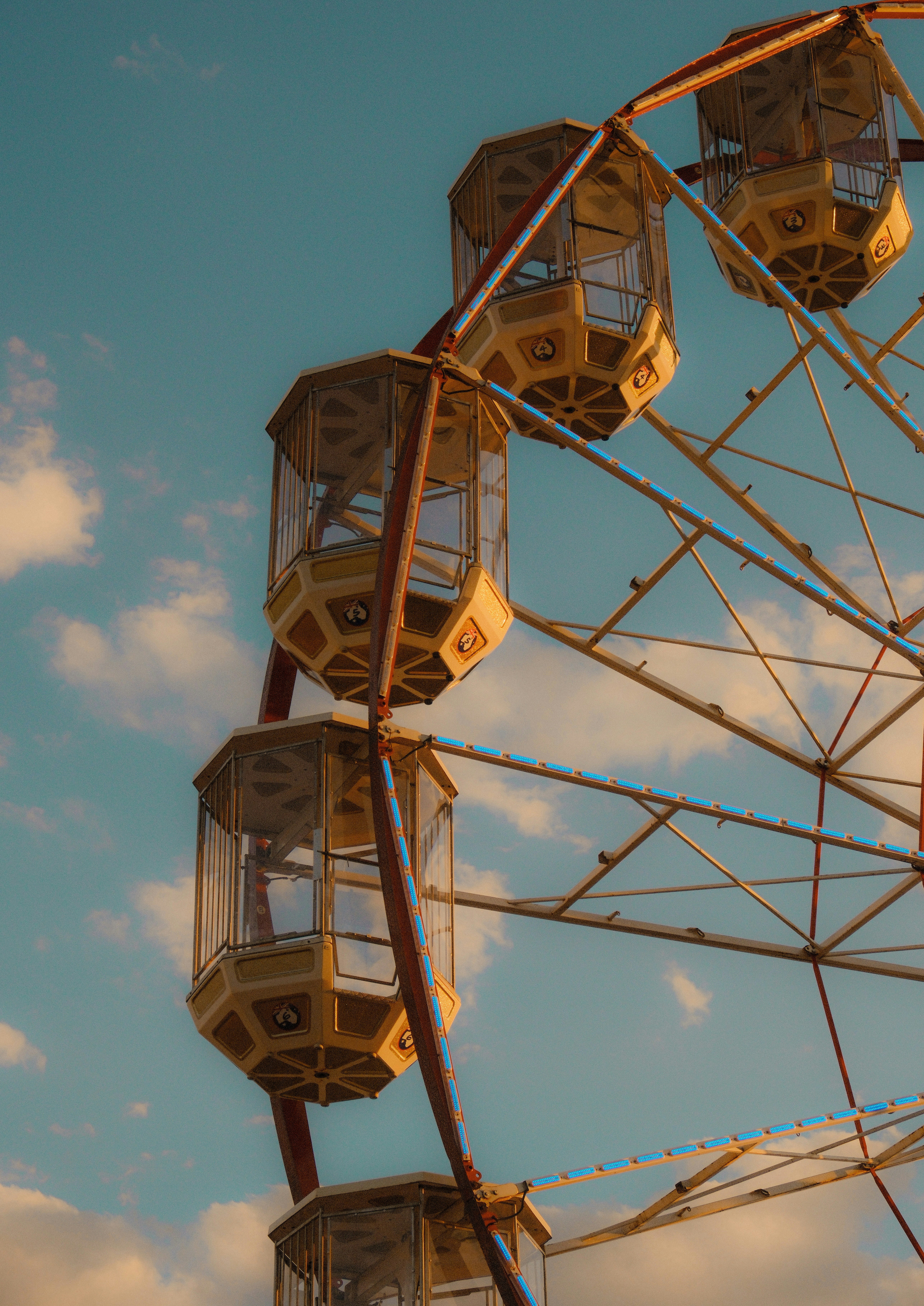 A ferris wheel against a blue sky with clouds.