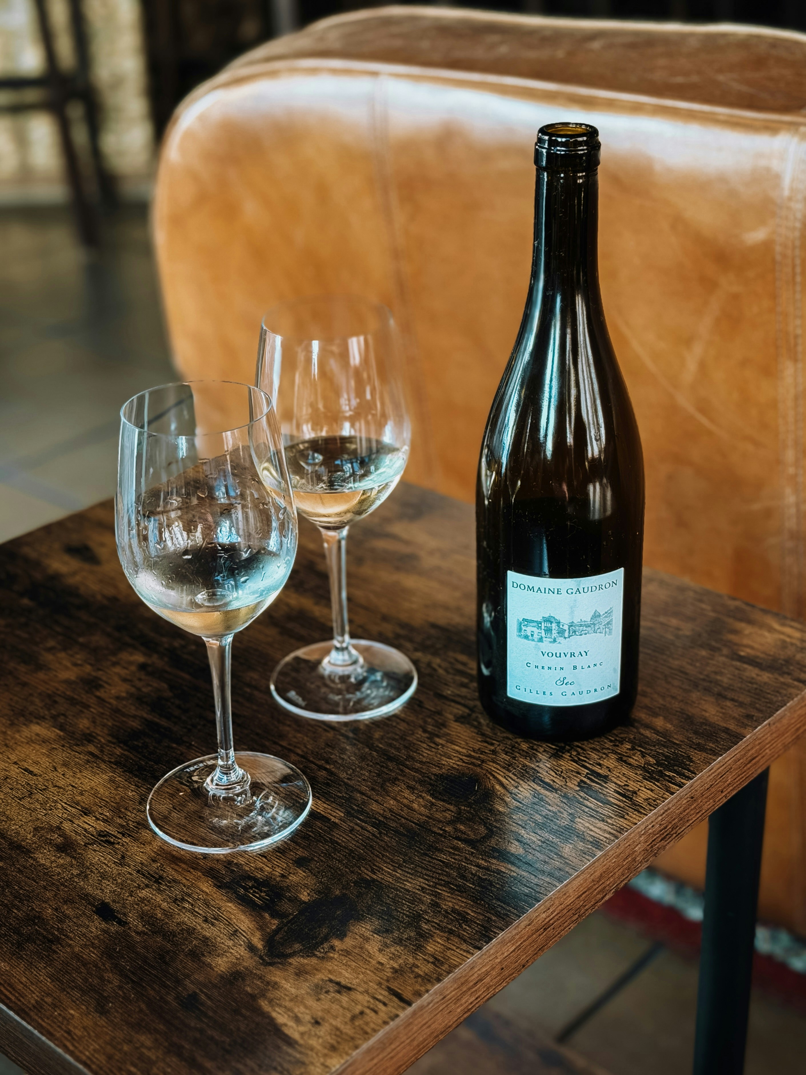Wine bottle and two glasses filled with white wine.