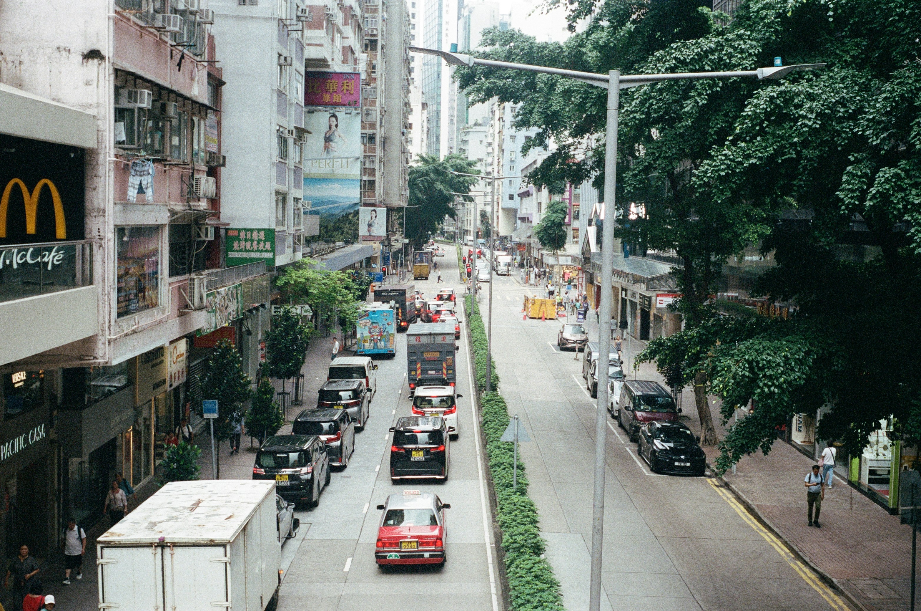 Rua Hong Kong com prédios, trânsito e uma placa do McDonald's.