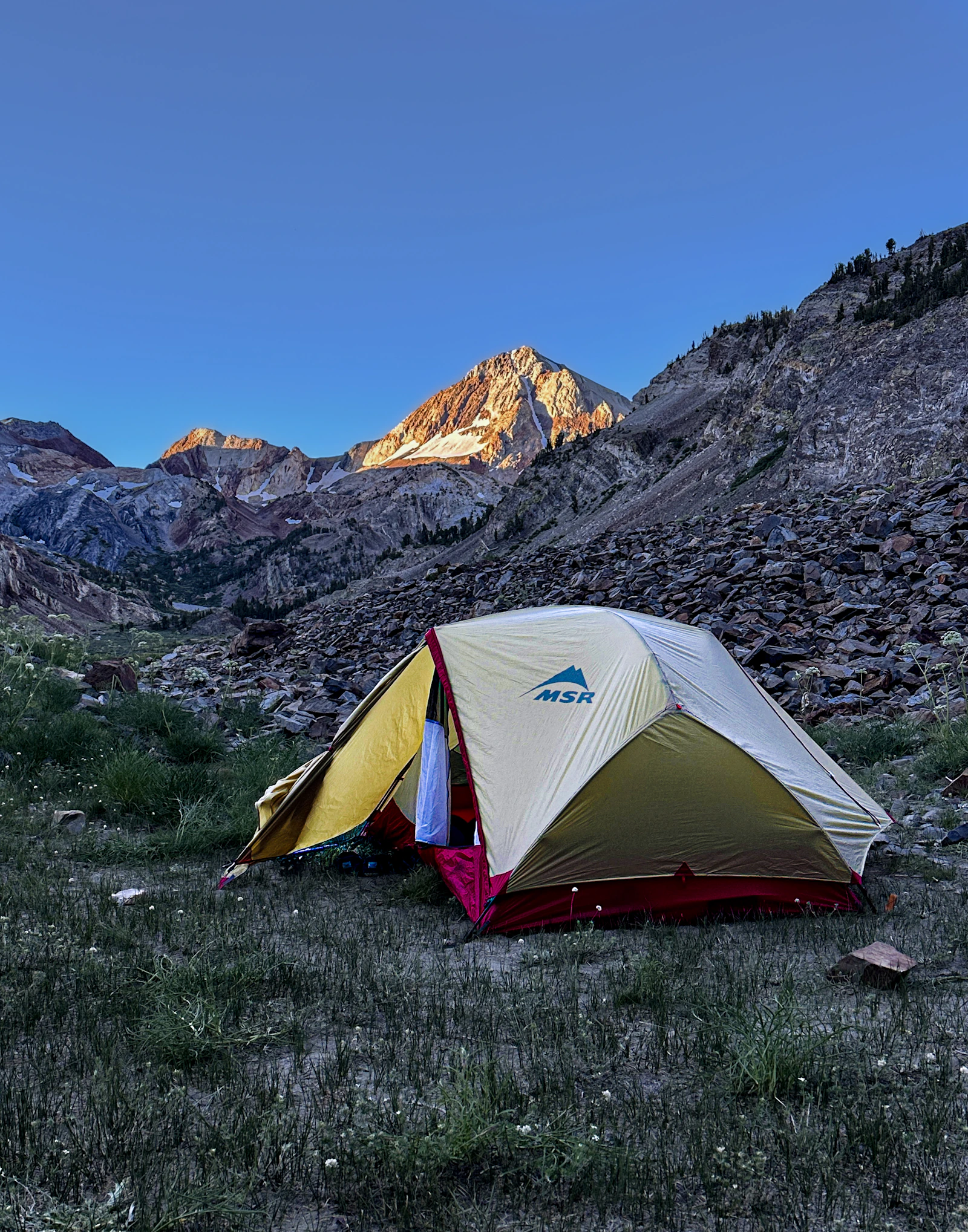 Camping tent set up in a mountain landscape