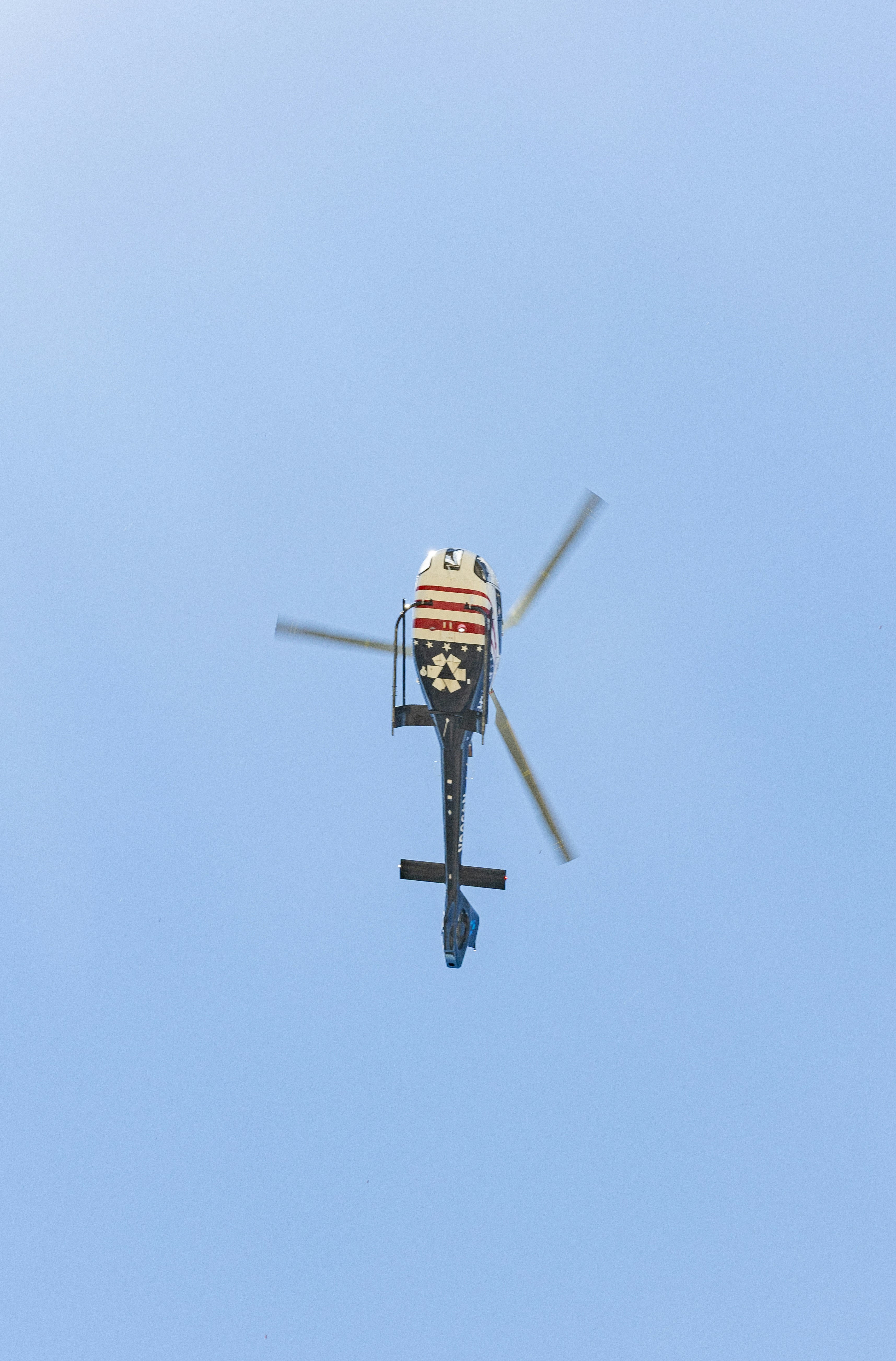 Helicopter flying overhead with a patriotic tail design.