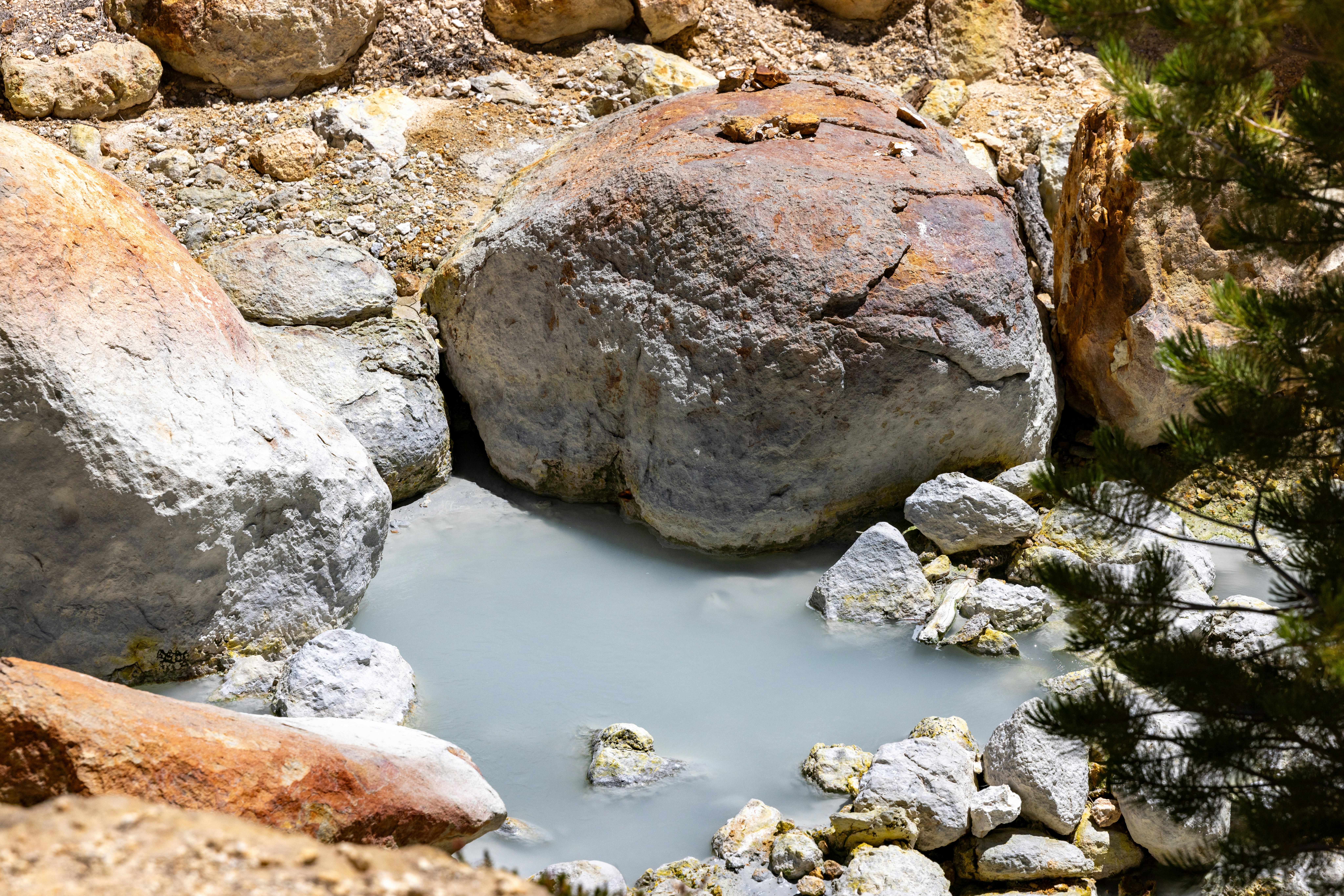 Milky blue water in a rocky natural hot spring.