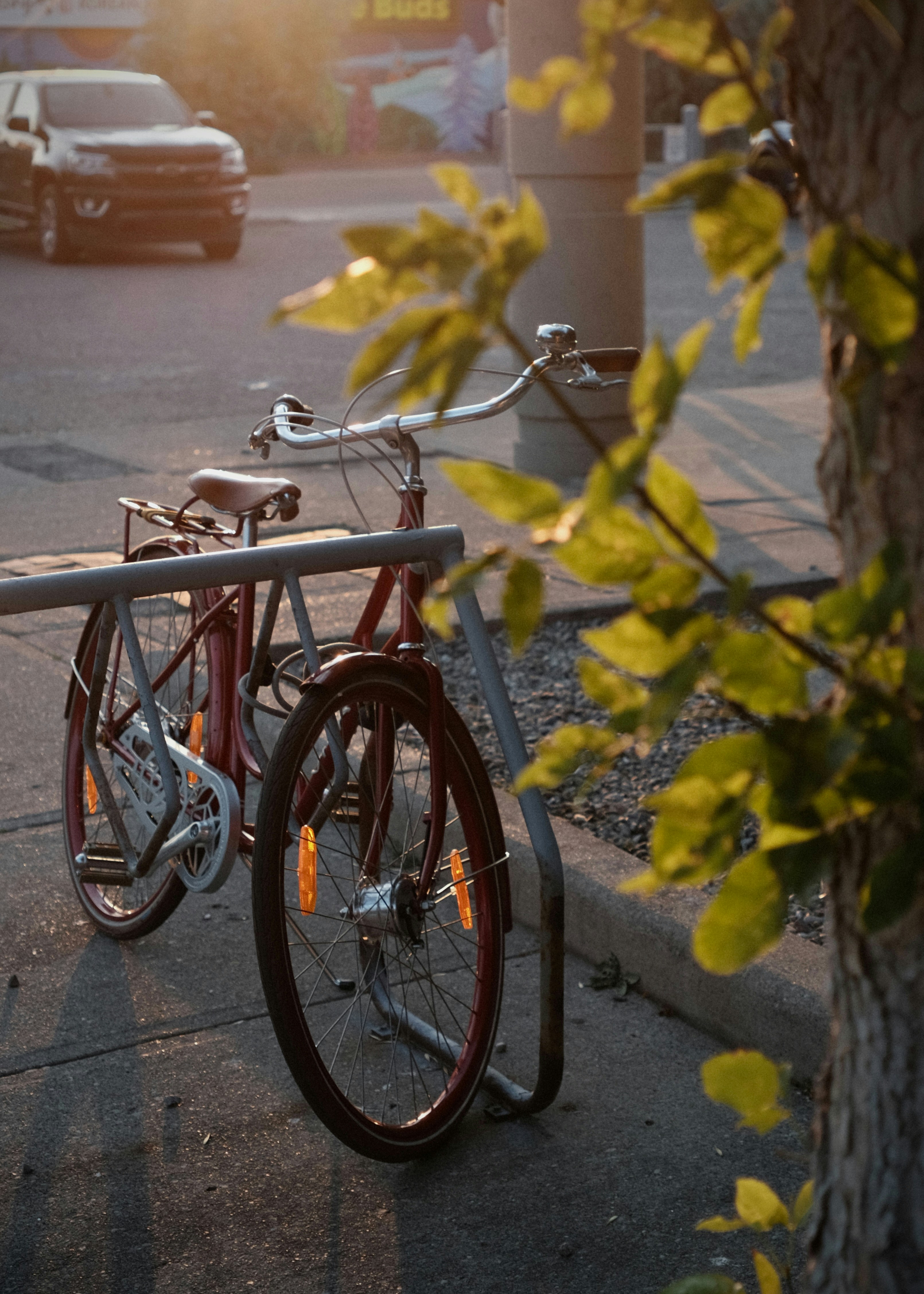 Two bicycles parked on a street at sunset