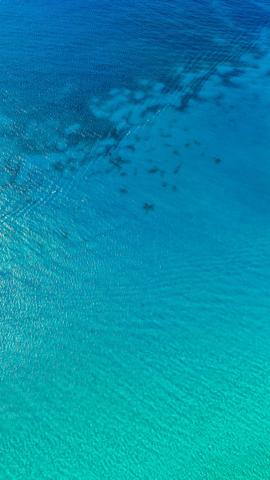 Clear turquoise water with visible underwater patterns