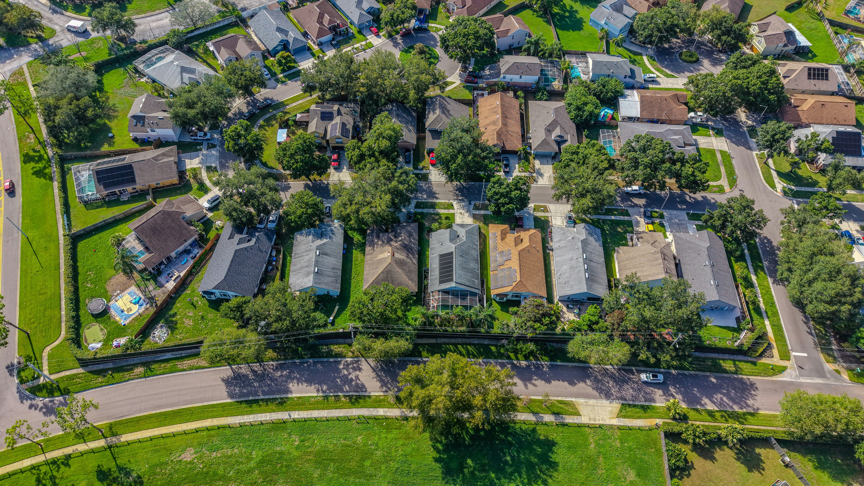 Aerial view of suburban houses, trees, and green fields