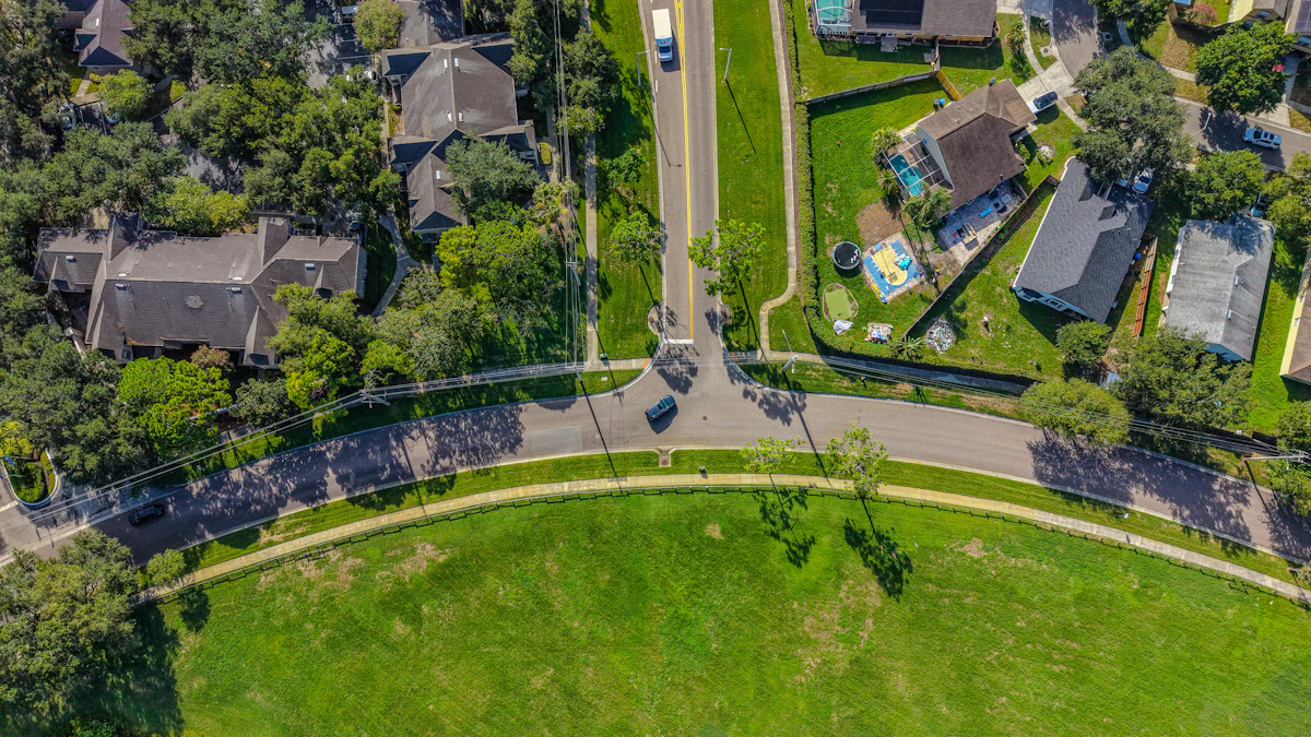 An aerial view of single-family homes backing onto a wide stretch of green open space