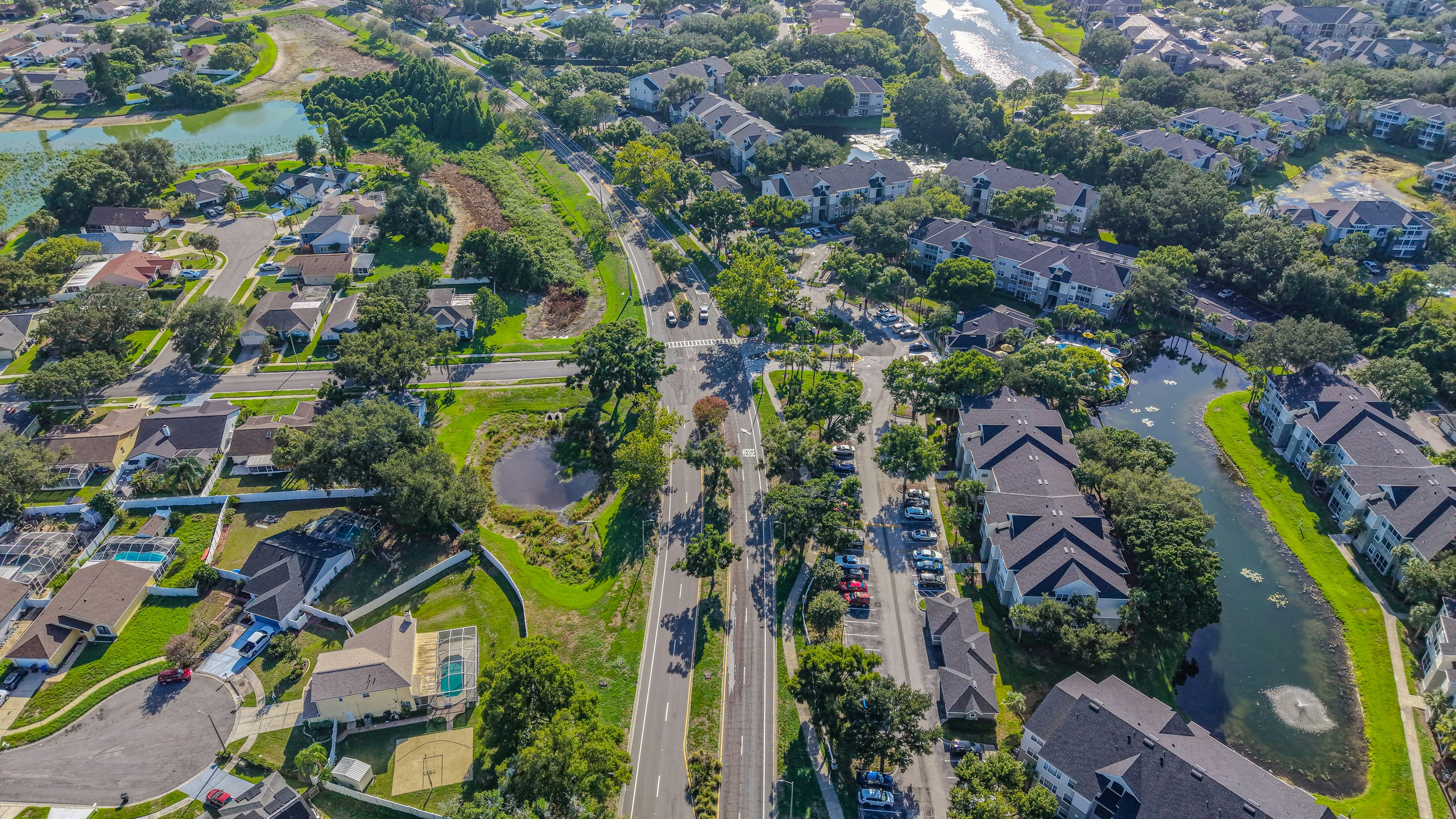 Residential area with houses, apartments, roads, and ponds from above