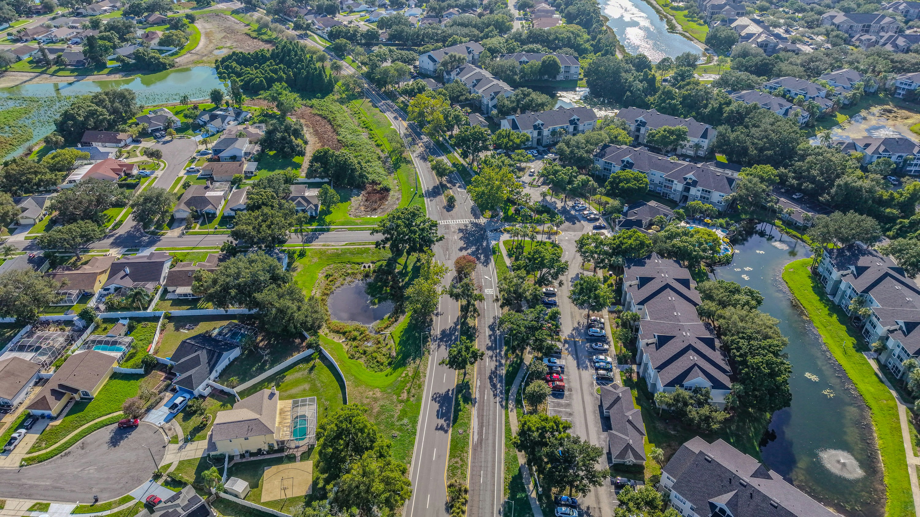 suburban houses aerial view - Aerial view of suburban houses, roads, trees, and water bodies.