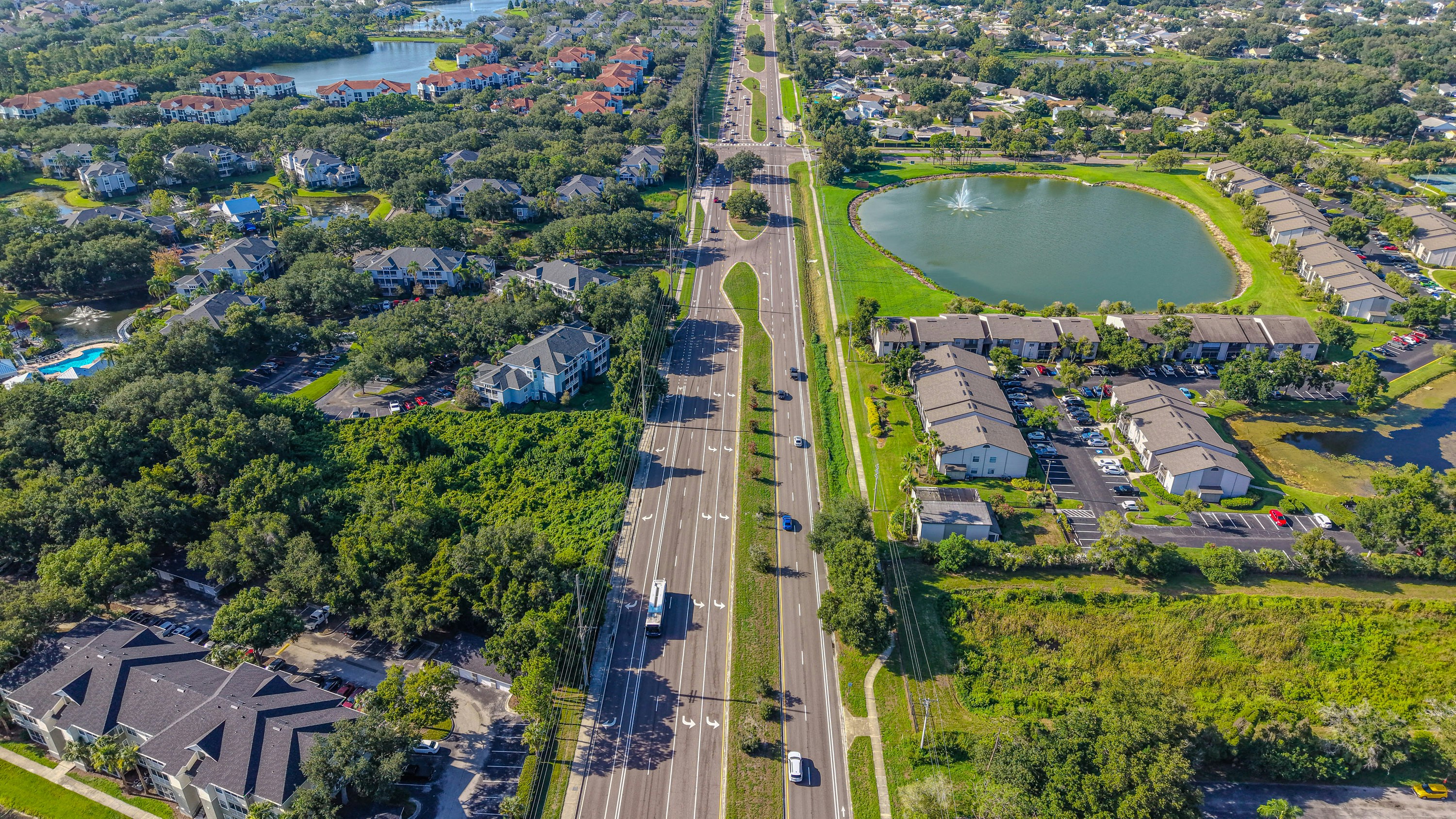 Aerial view of a long road, residential buildings, and lakes