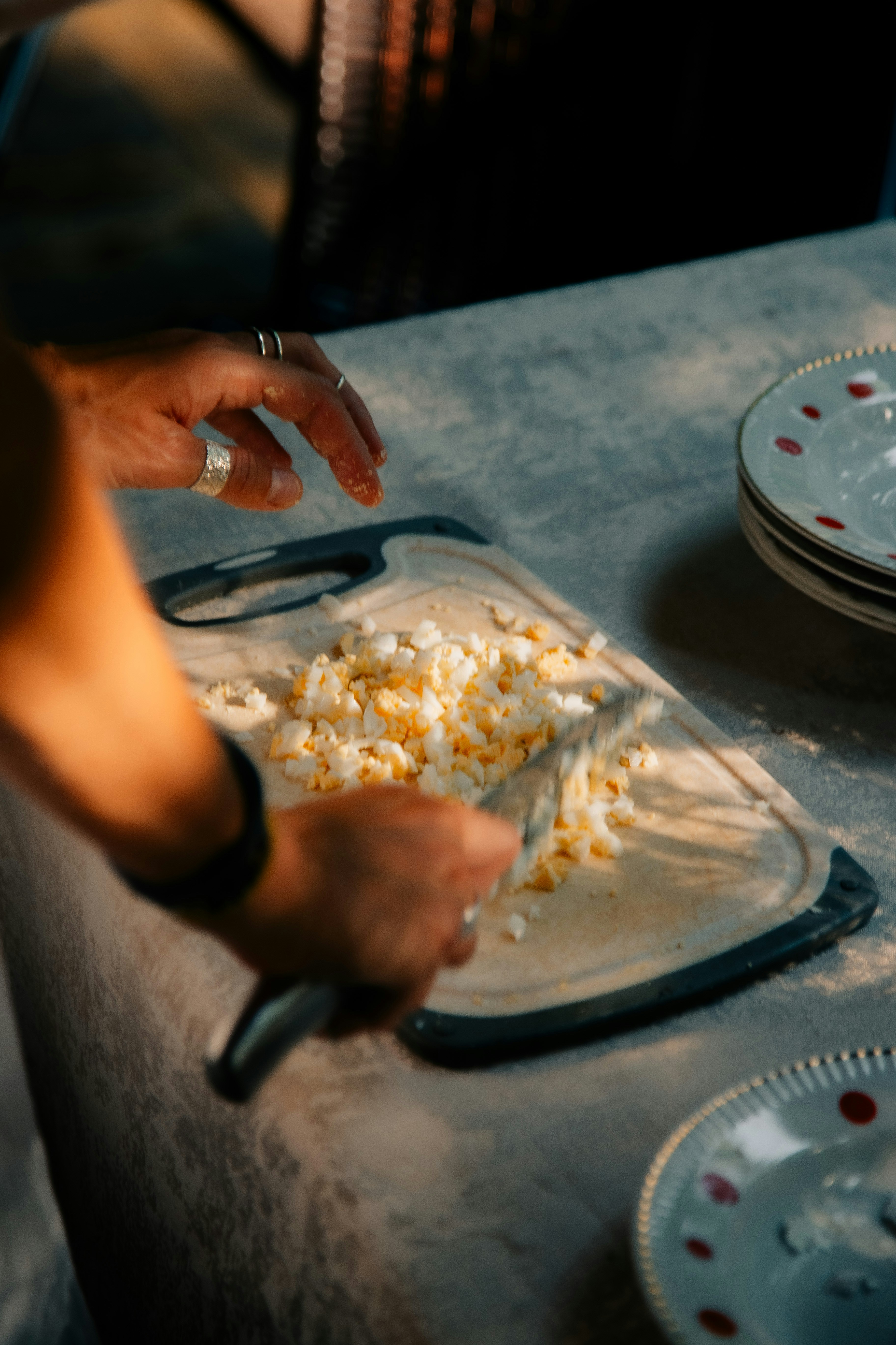 Hands chopping eggs on a cutting board
