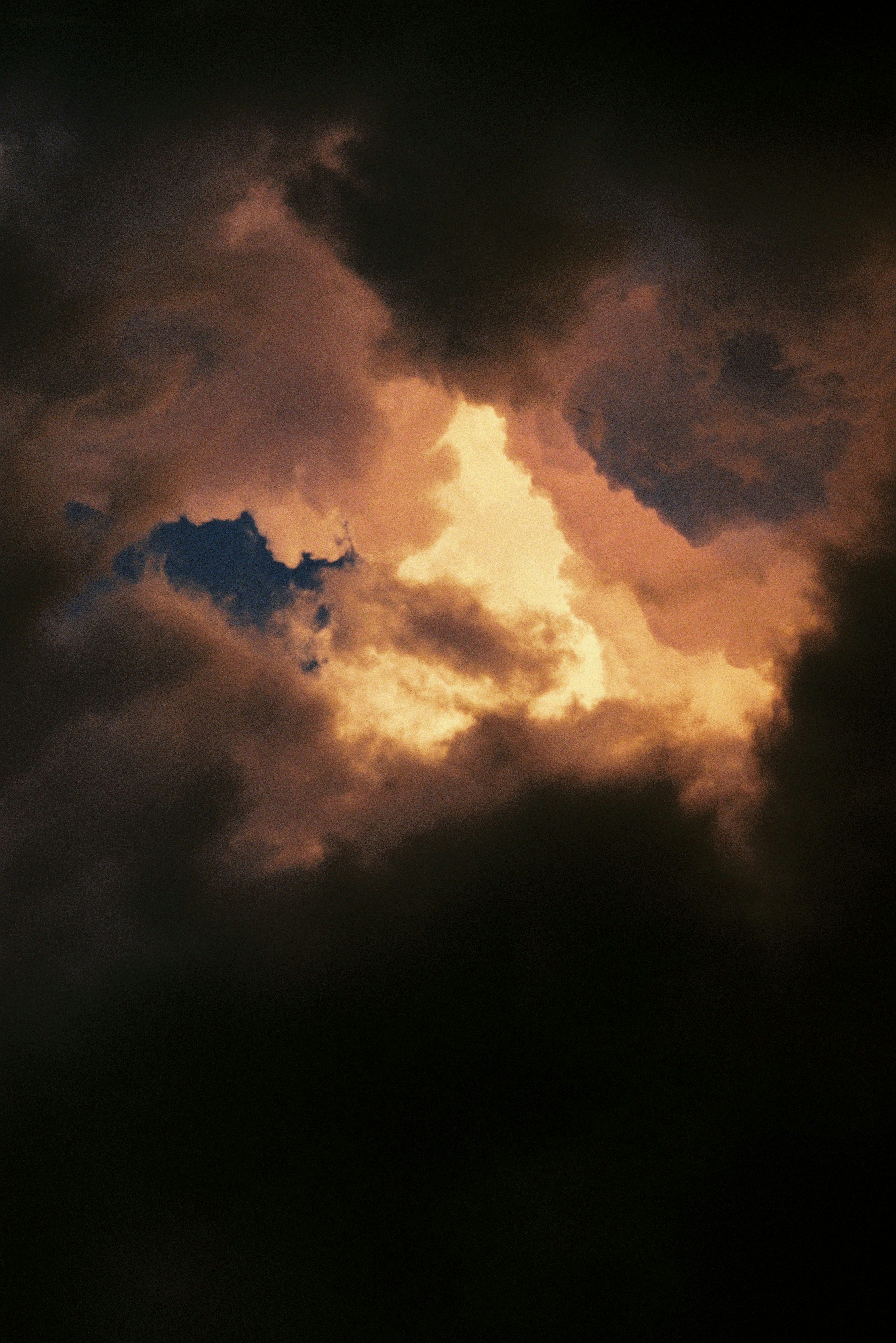 Golden light illuminates dark, dramatic storm clouds.