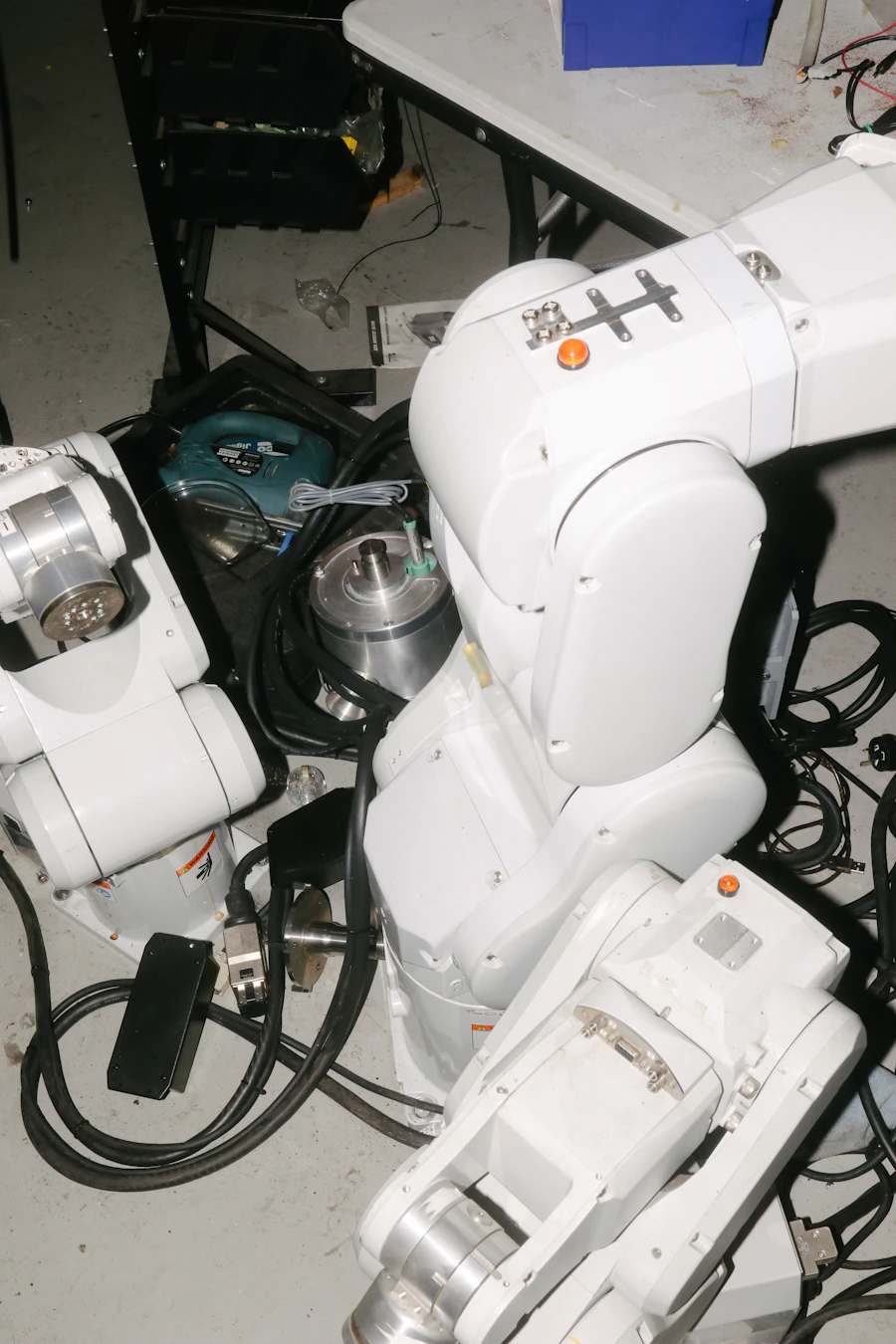 Robotic arms and wiring on a robotics workshop floor