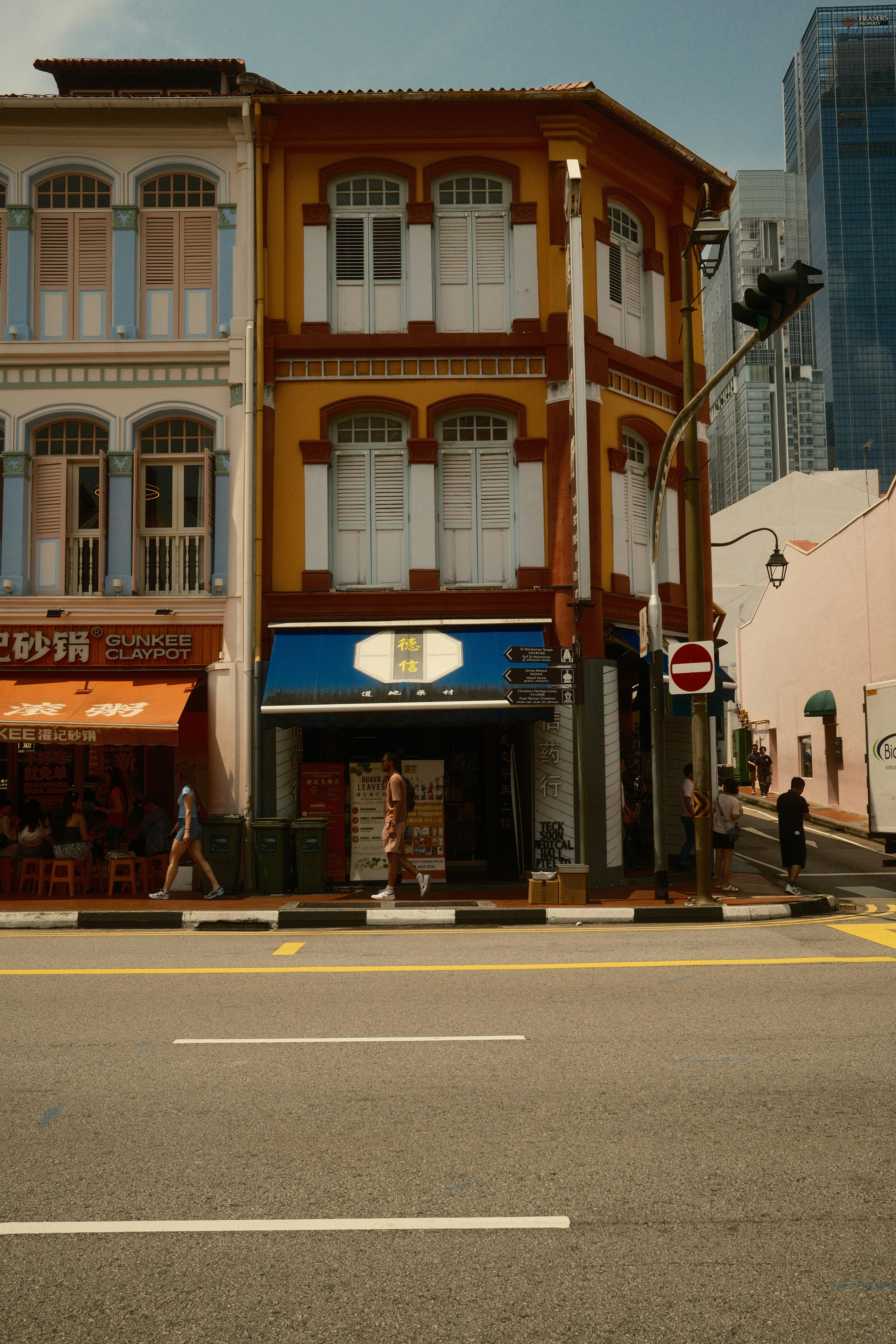 Colorful traditional buildings line a street with people walking.