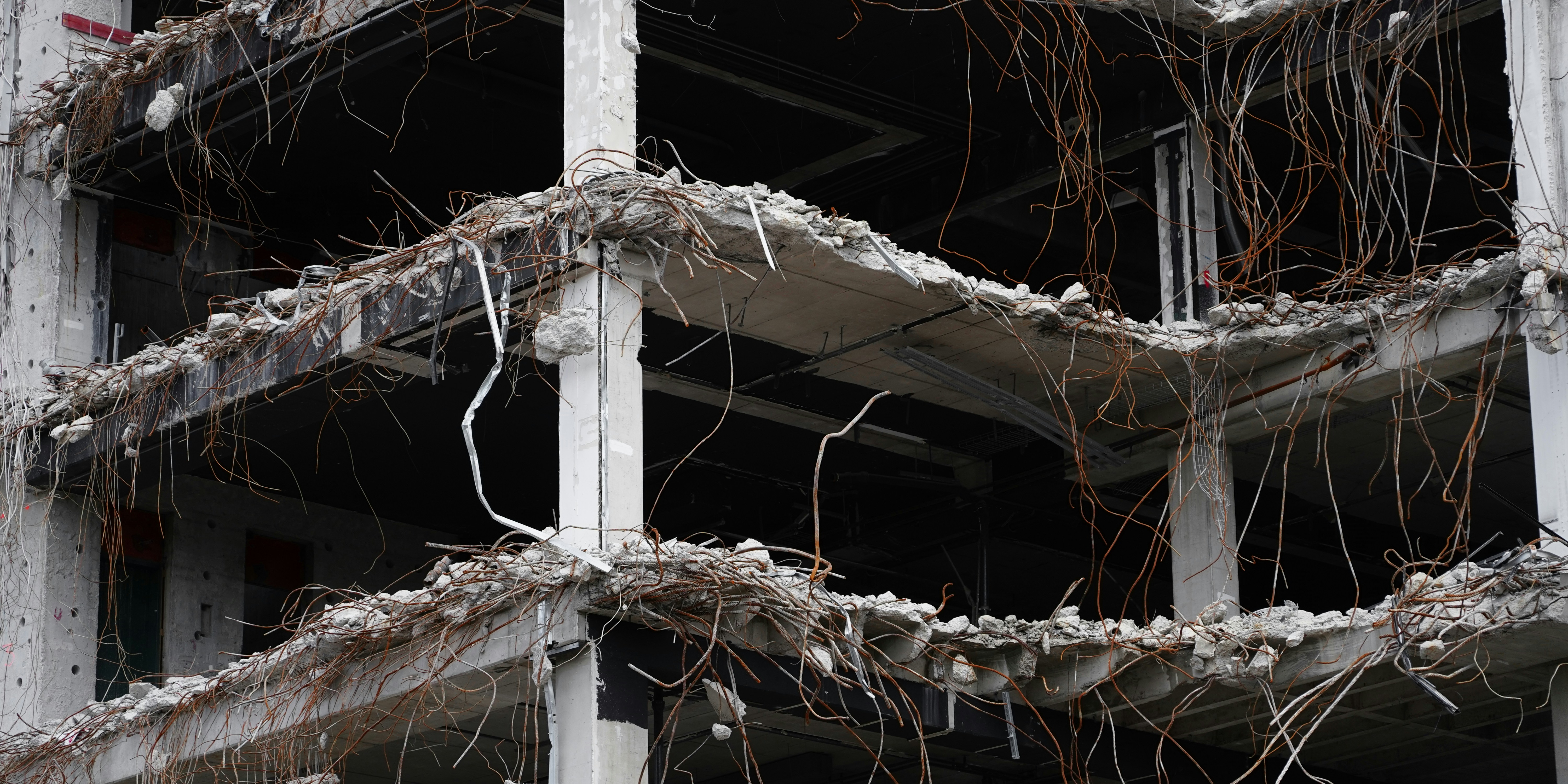 Damaged building structure with exposed rebar during demolition.