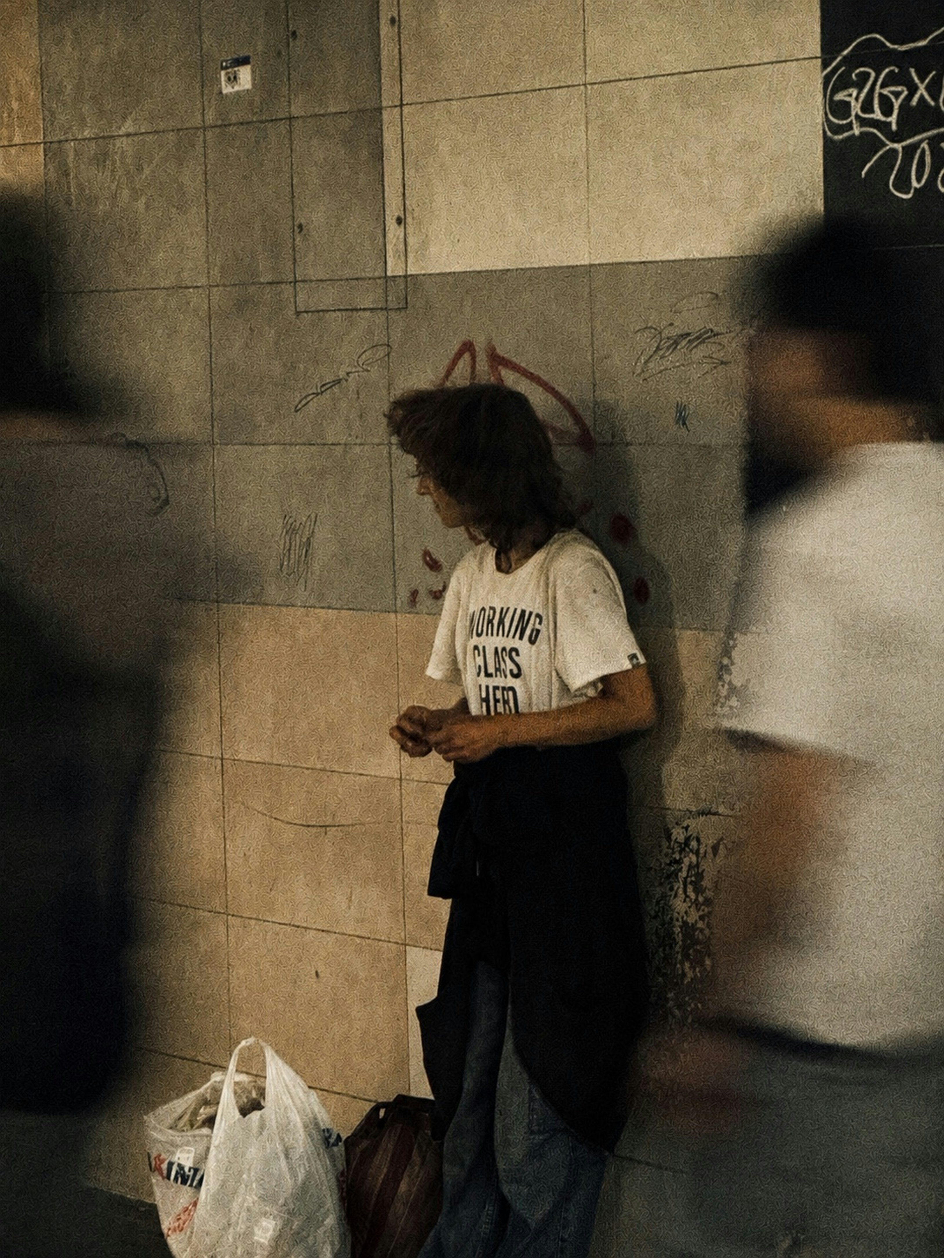 Person im "Arbeiterklasse-Helden"-Shirt an einer Graffiti-Wand