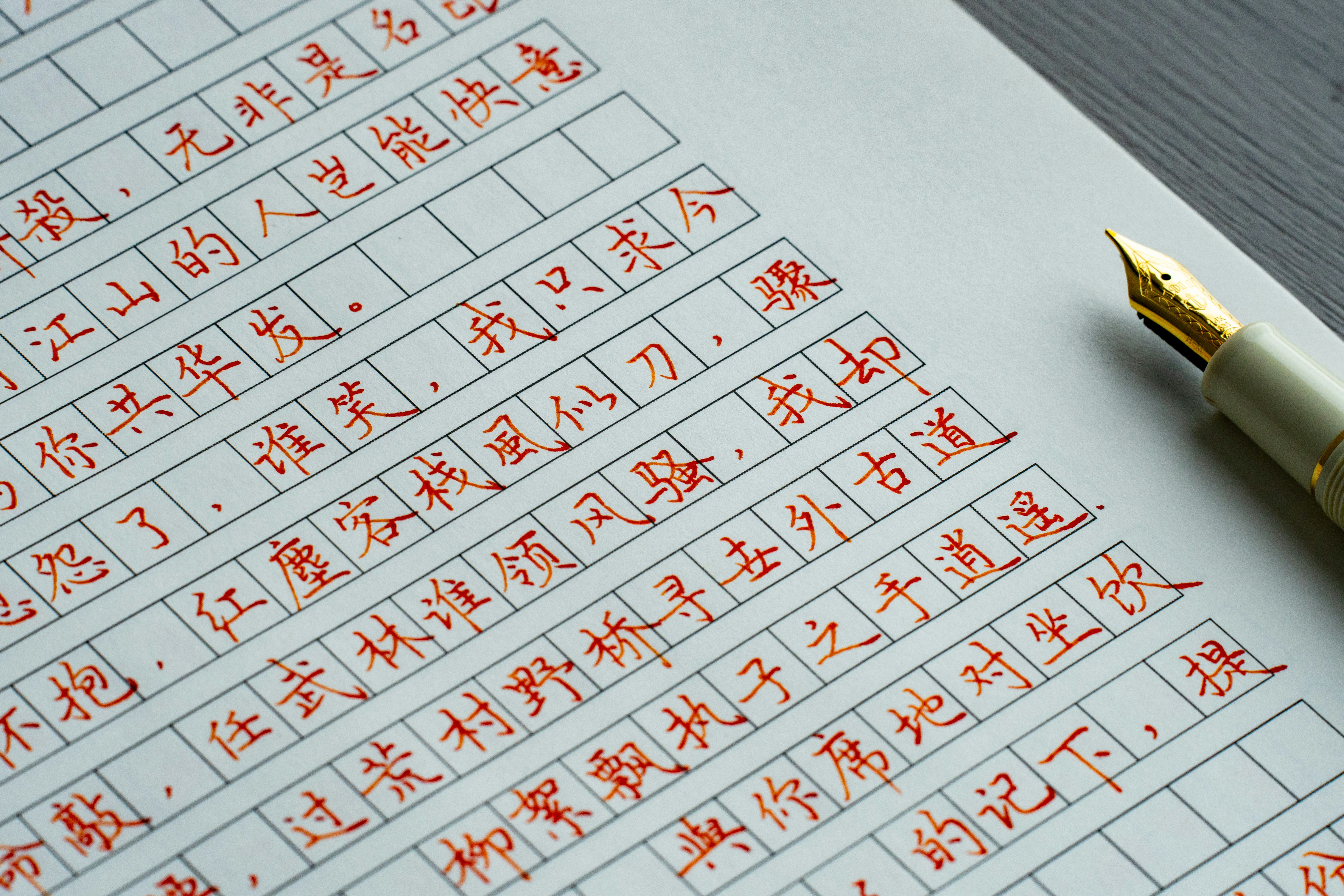 Close-up of a golden fountain pen and red chinese calligraphy