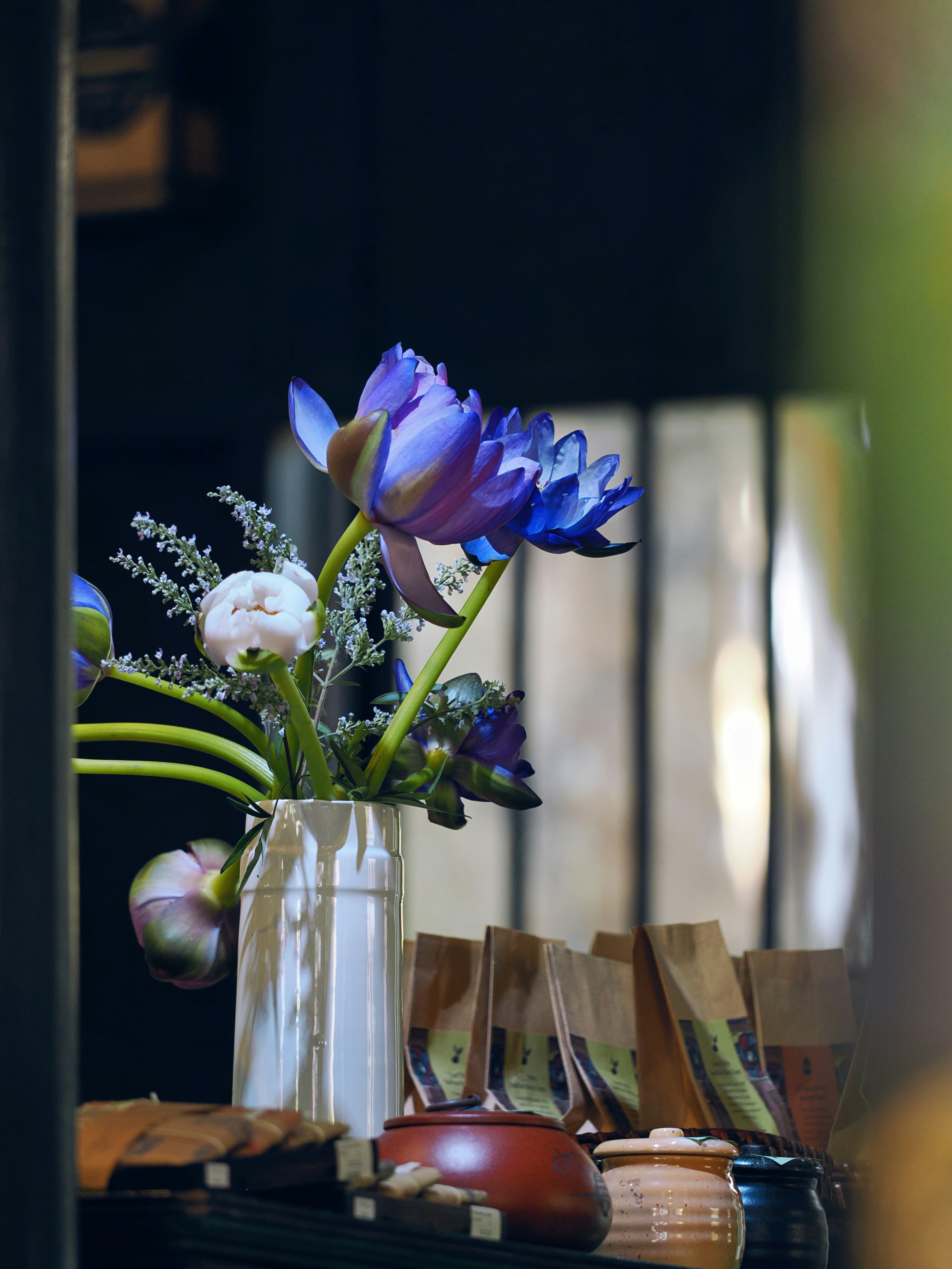 Vase with vibrant blue water lilies and other flowers indoors.
