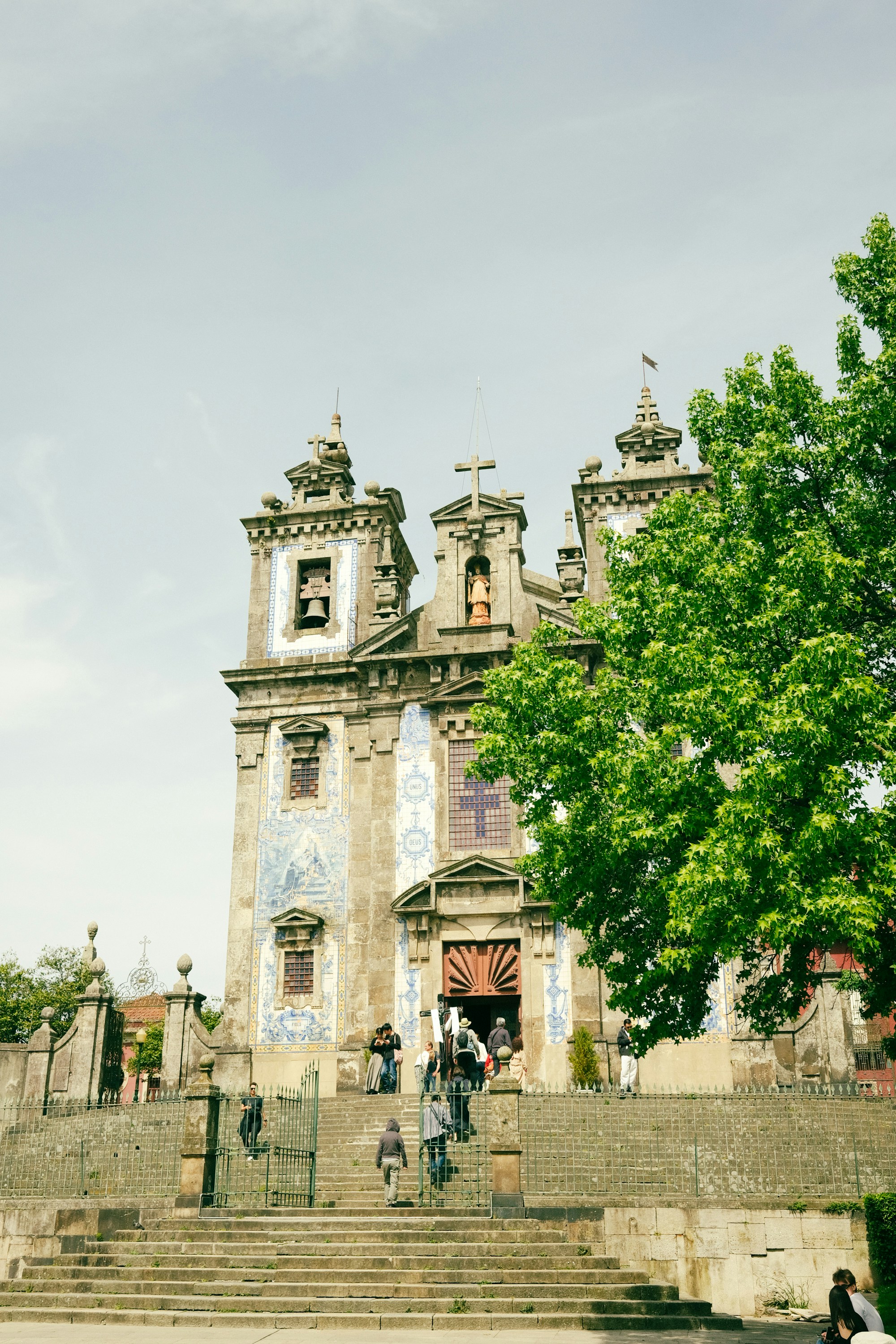 Prunkvolle historische Kirche mit Menschen, die die großen Steinstufen hinaufsteigen