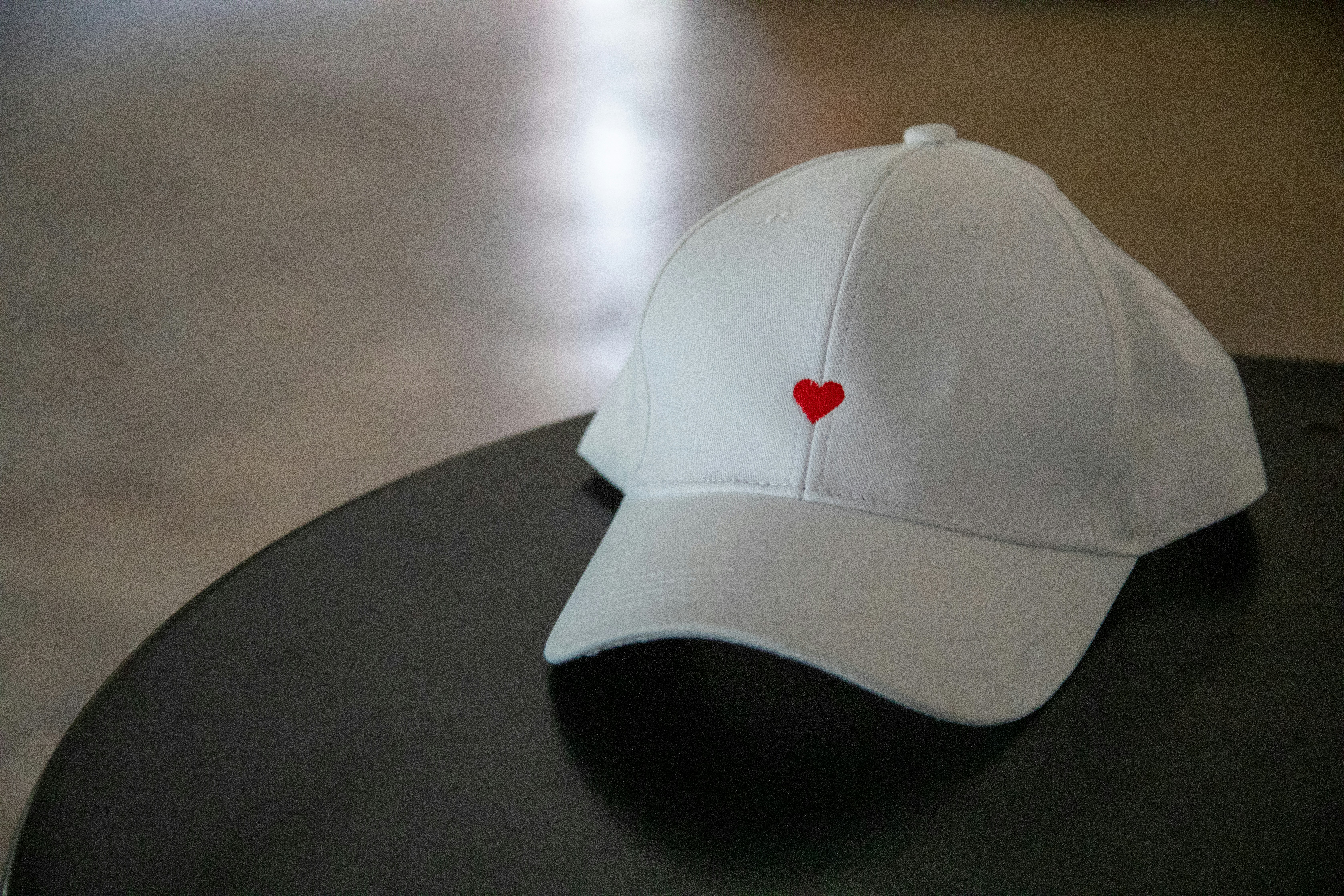 A white baseball cap with a red heart.