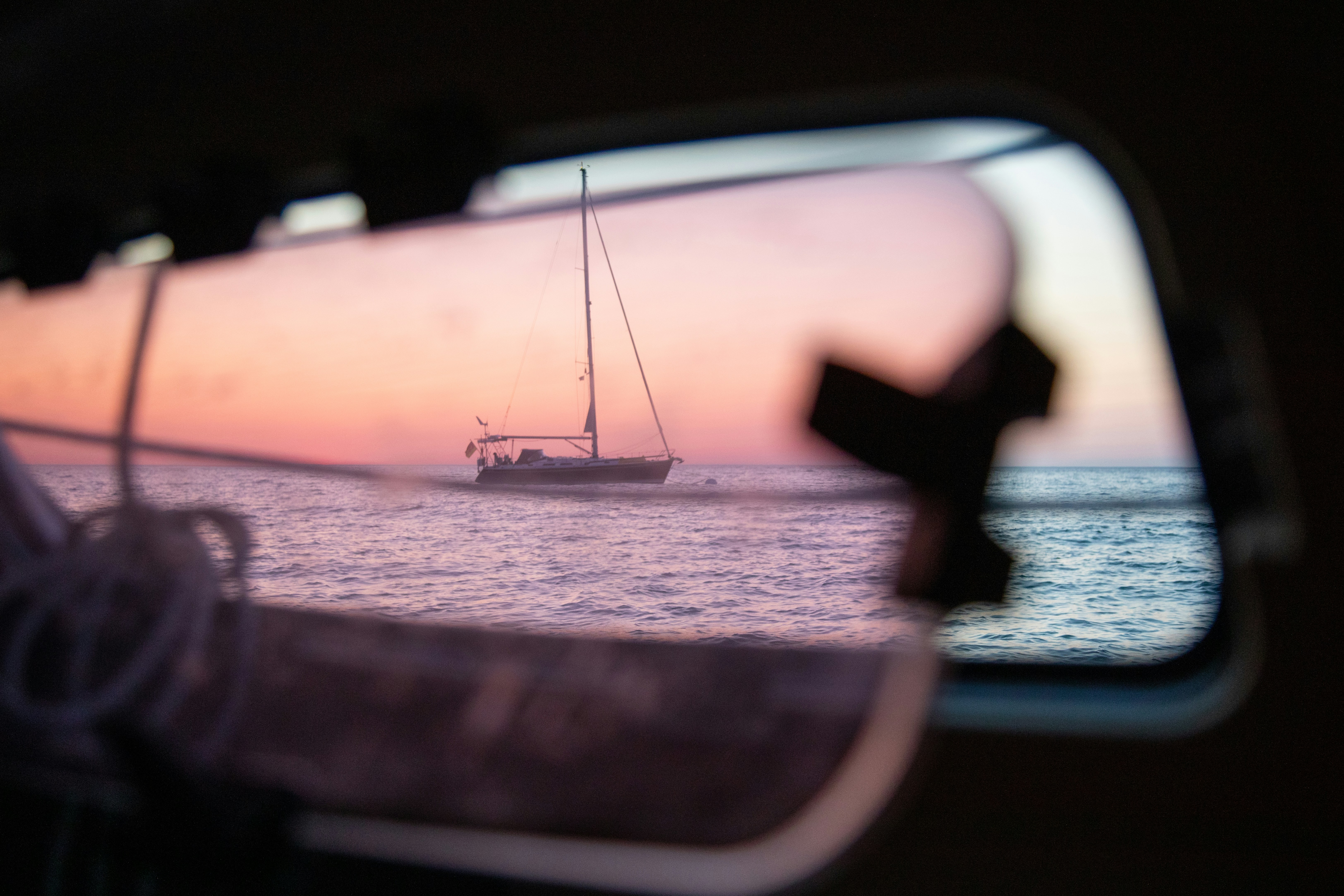 Sailboat reflected in a mirror at sunset.