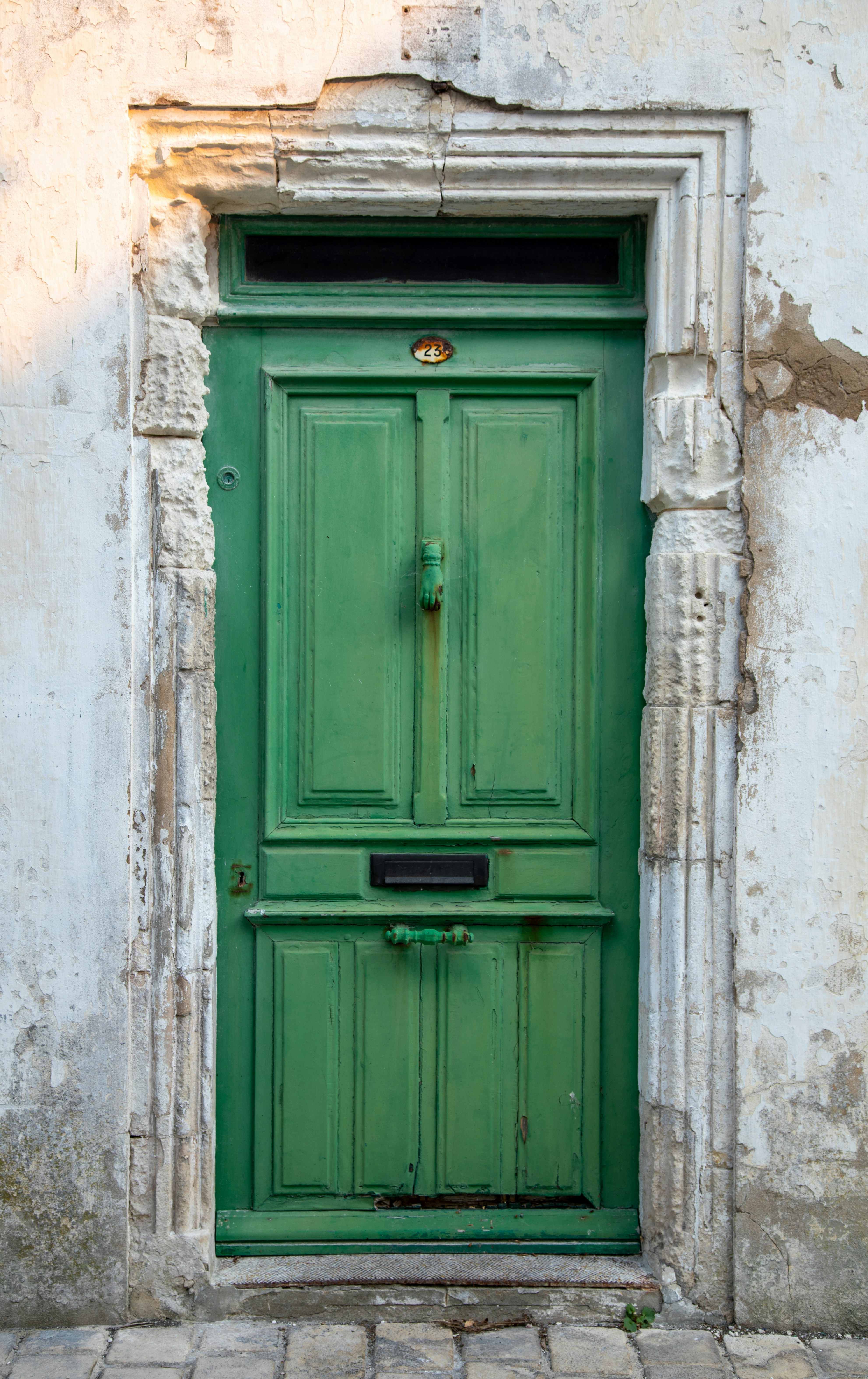 Weathered green door in an aged stone doorway.