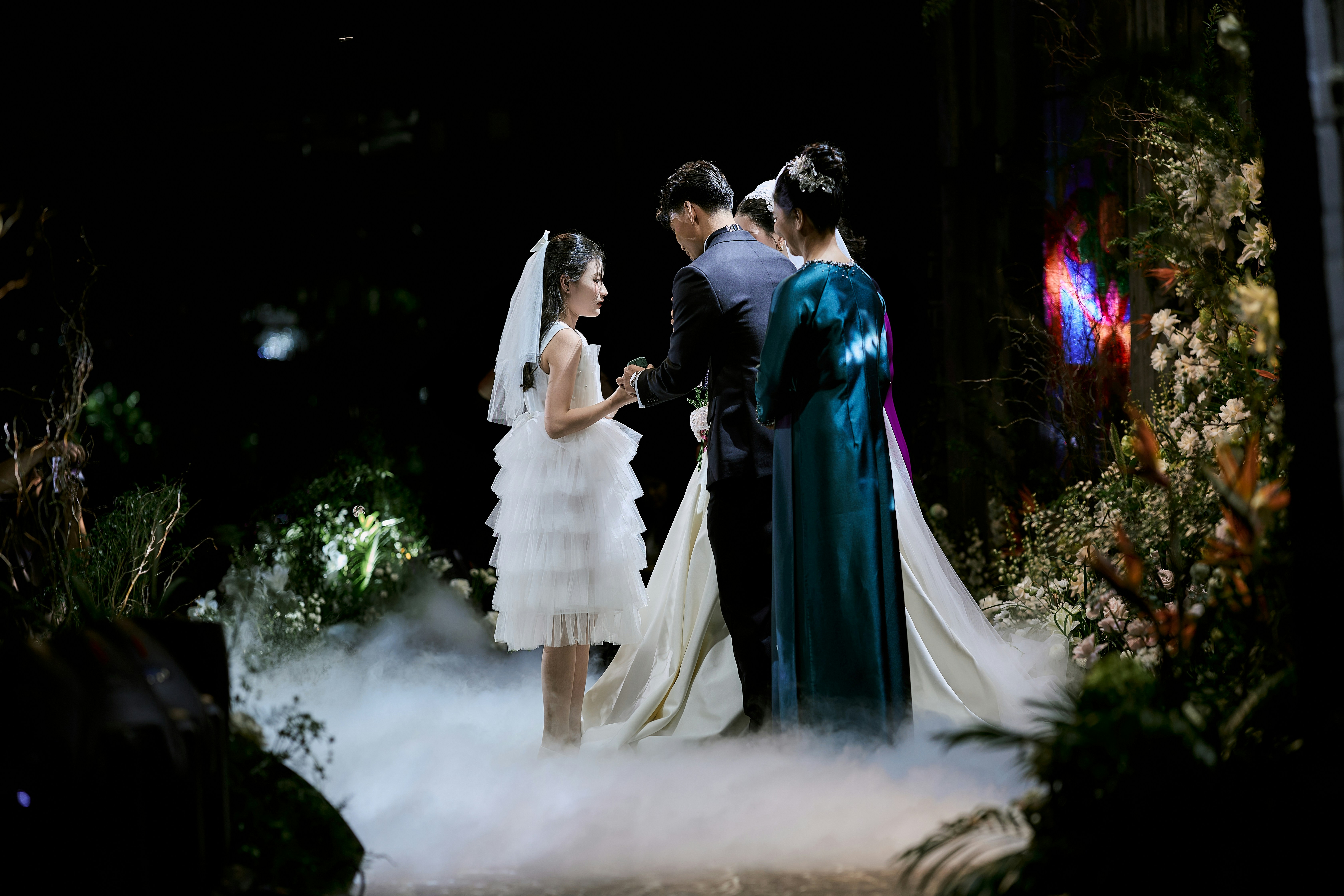 Bride, groom, and girl at an ethereal wedding ceremony