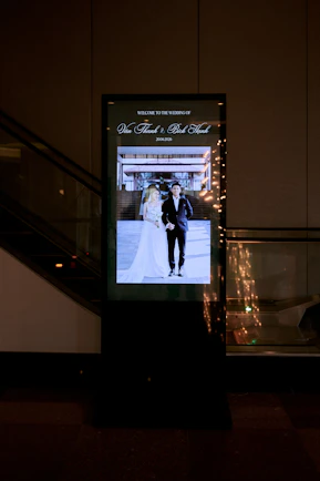A glowing digital display shows a wedding couple