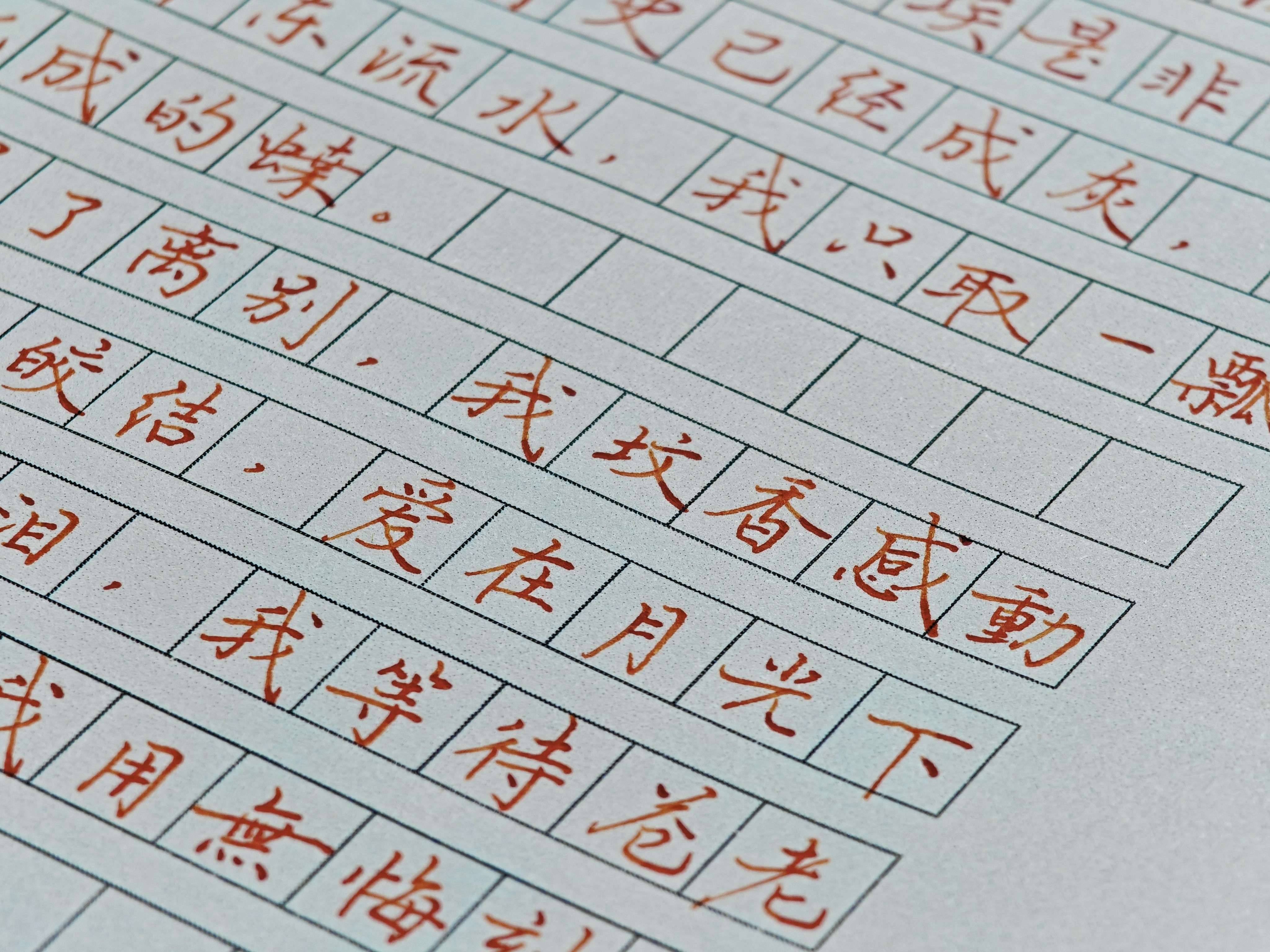 Red chinese characters handwritten on gridded paper. photo – Free Paper ...