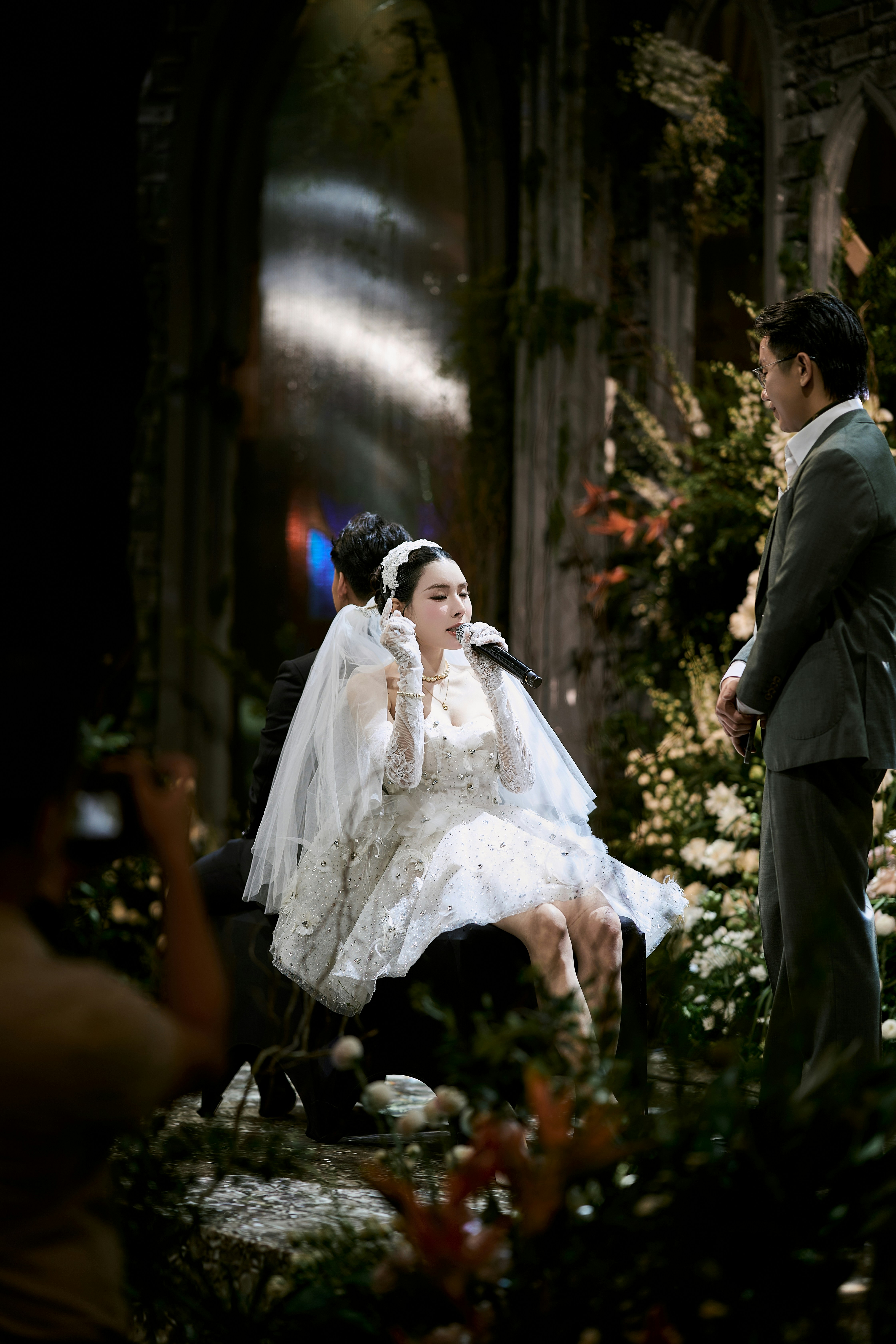 Bride sings at her wedding ceremony with groom watching