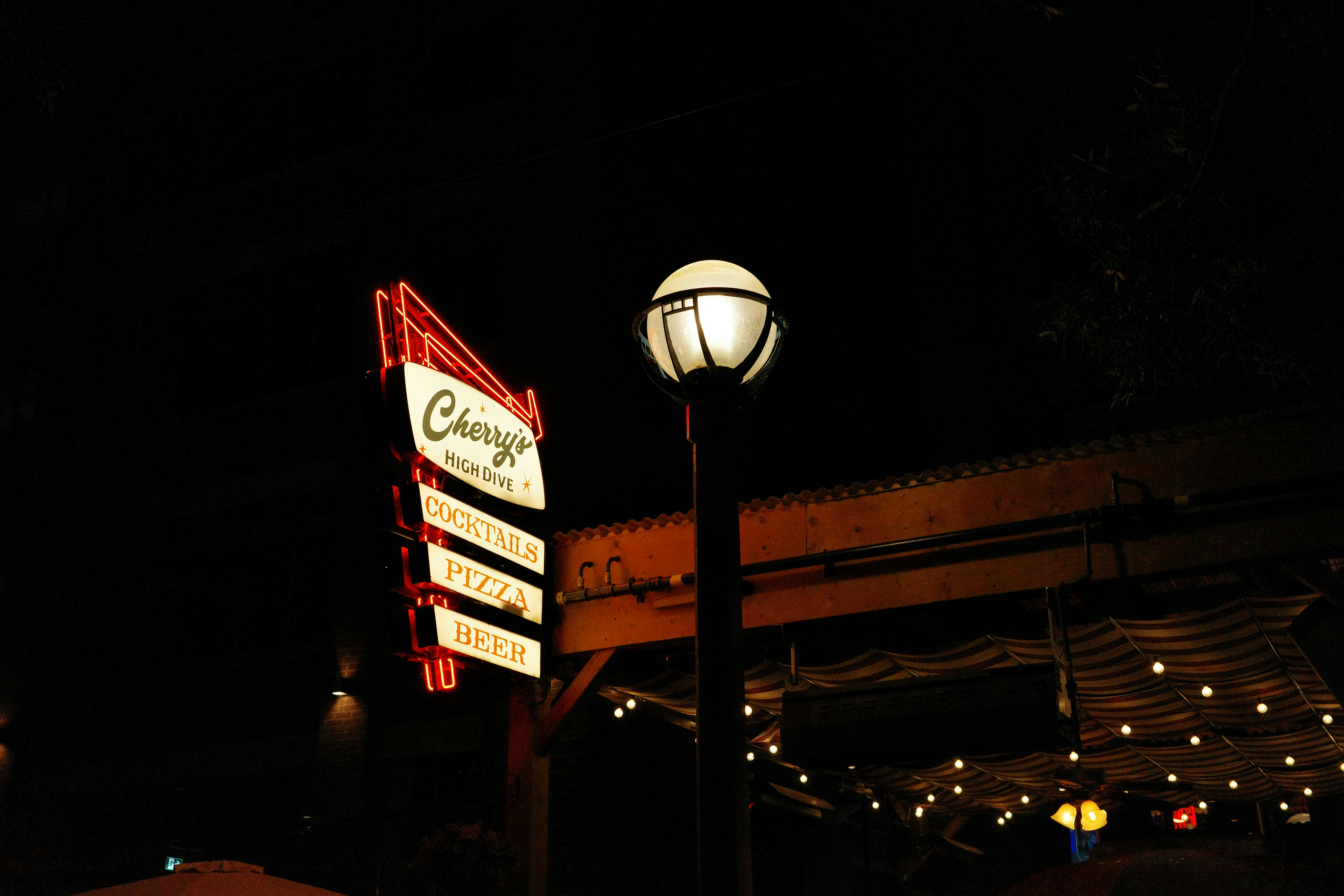 Postes de luz e letreiro de neon da Chevy à noite