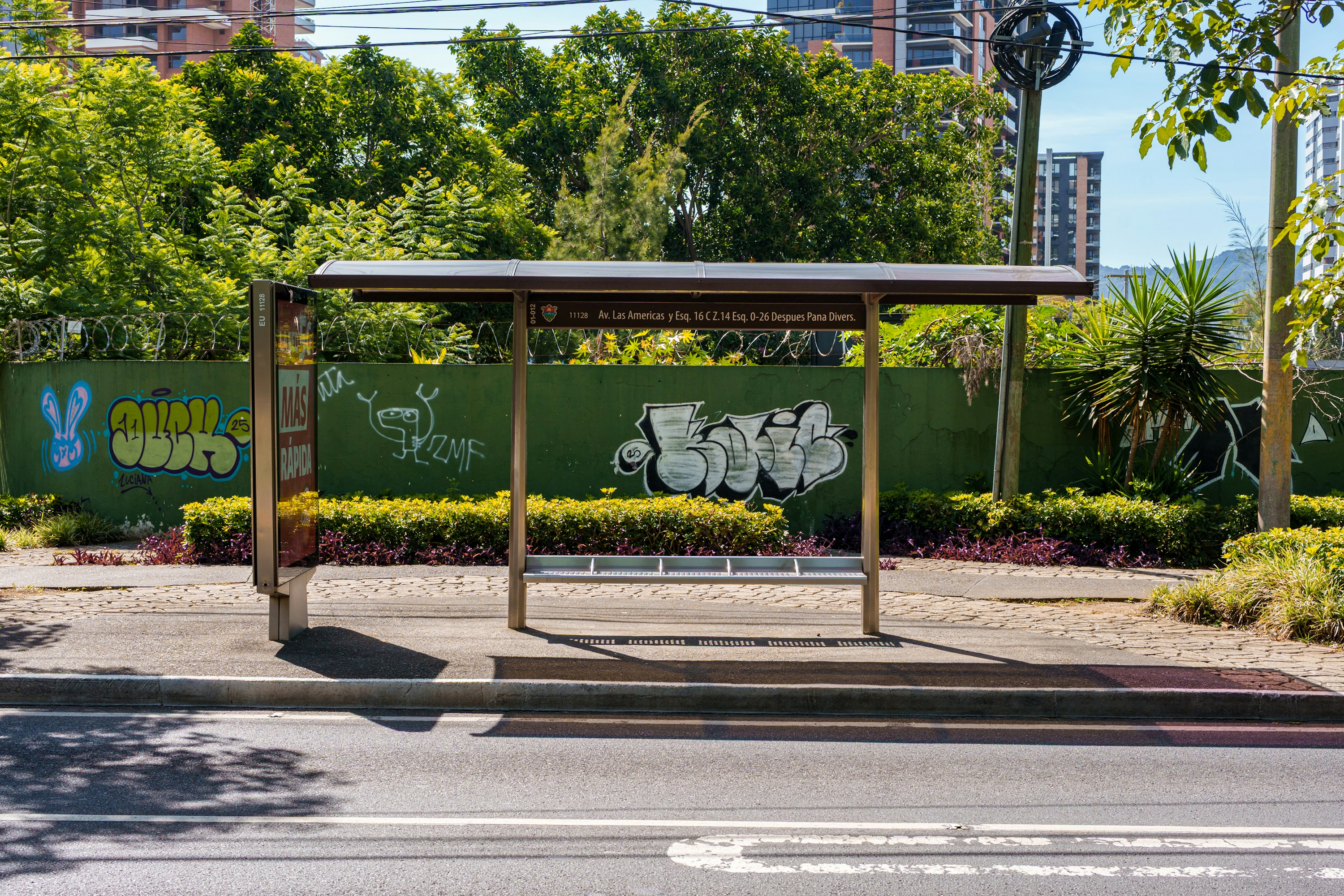 Bus stop shelter with graffiti on a sunny day