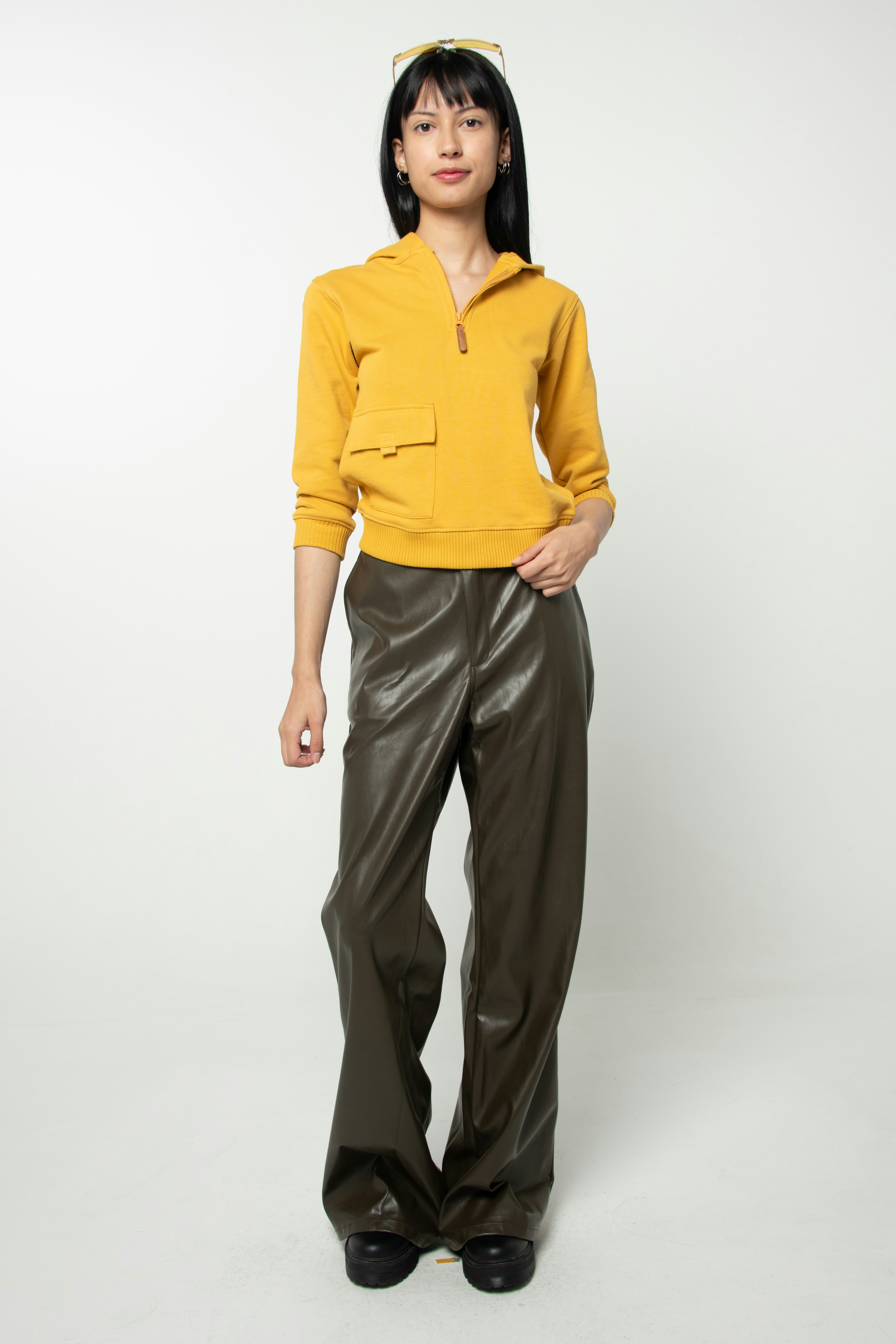 Jeune femme en haut jaune et pantalon large foncé