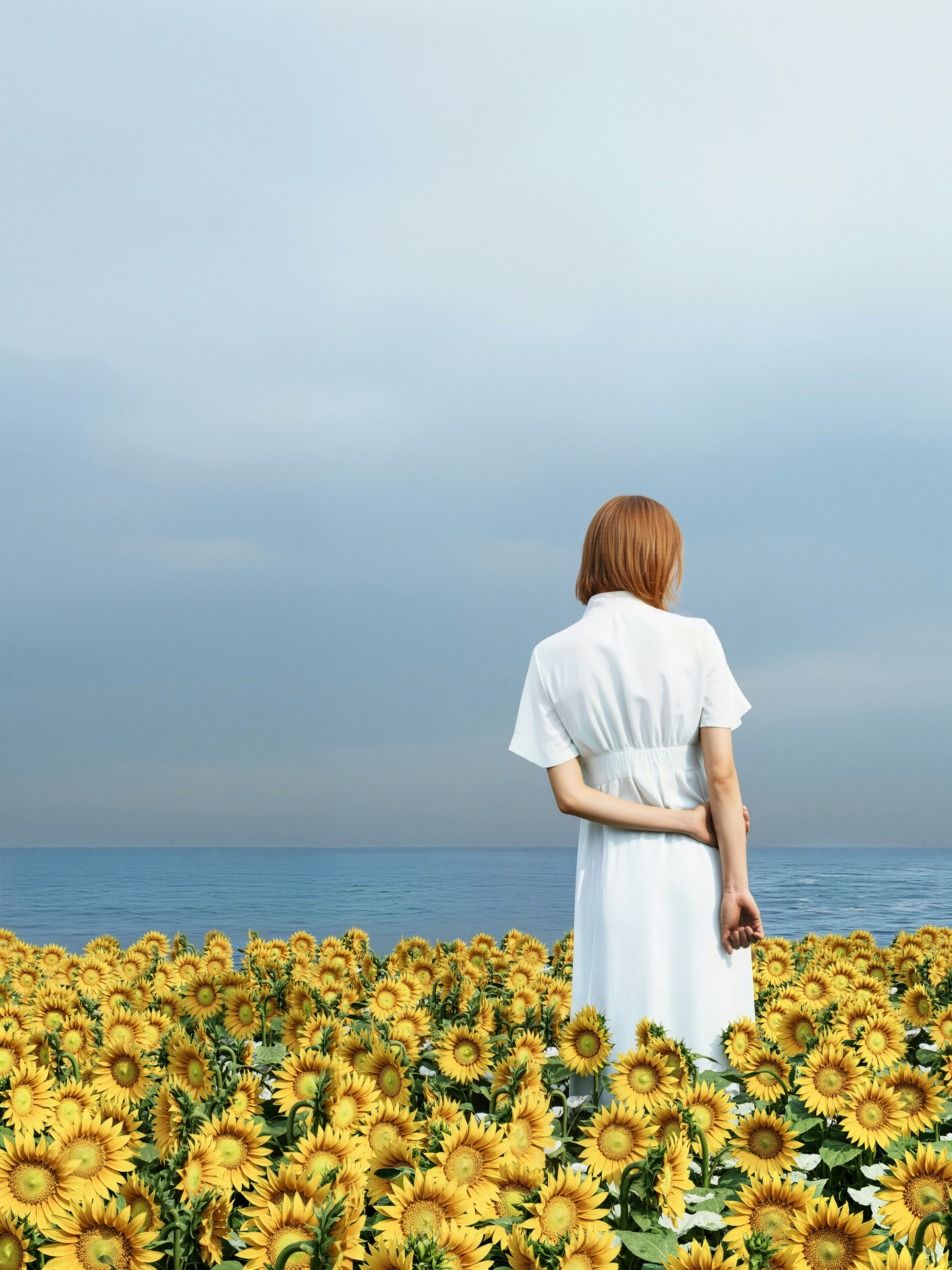 Woman in white dress in sunflower field near ocean