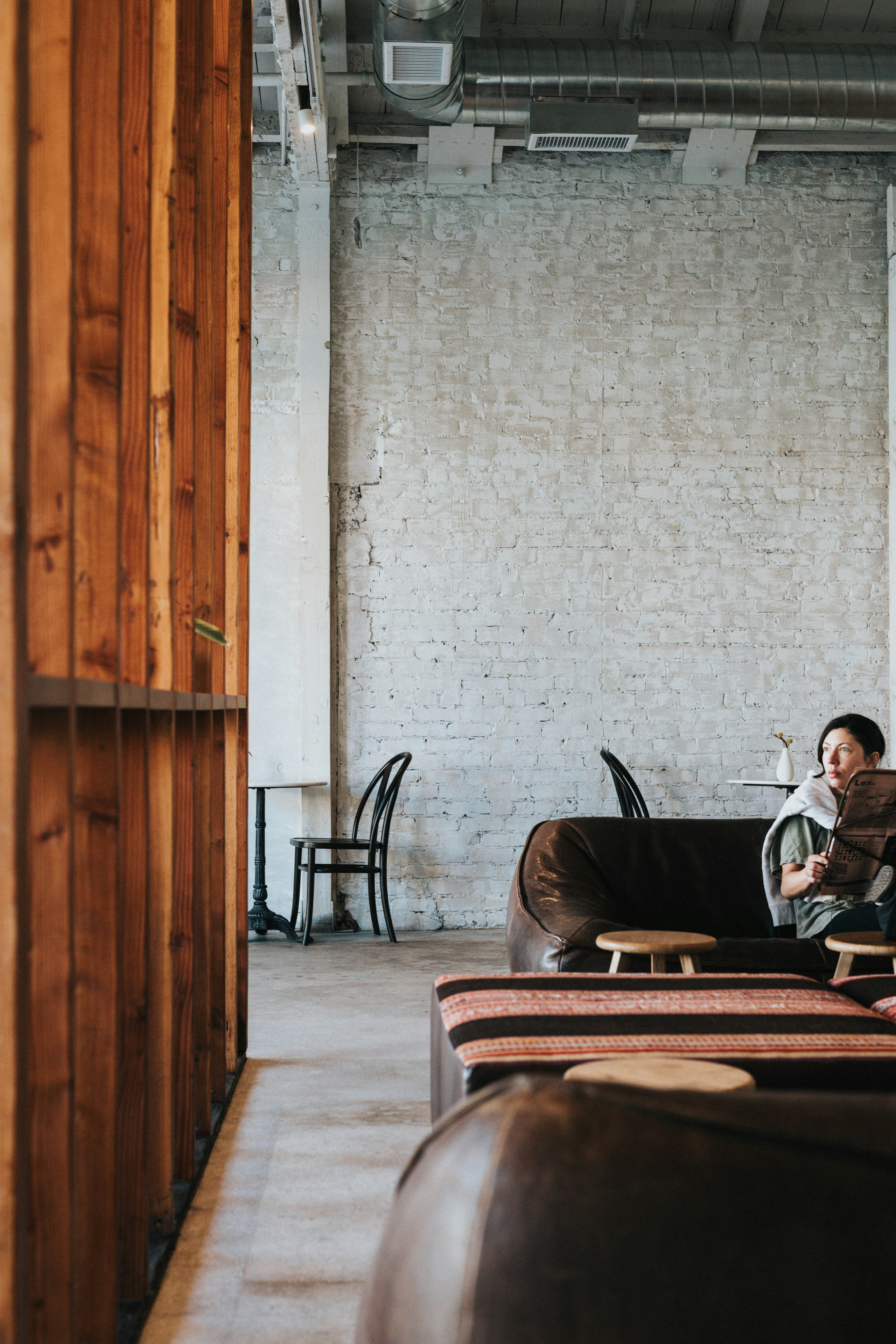 Person relaxing on a leather couch in a modern cafe.