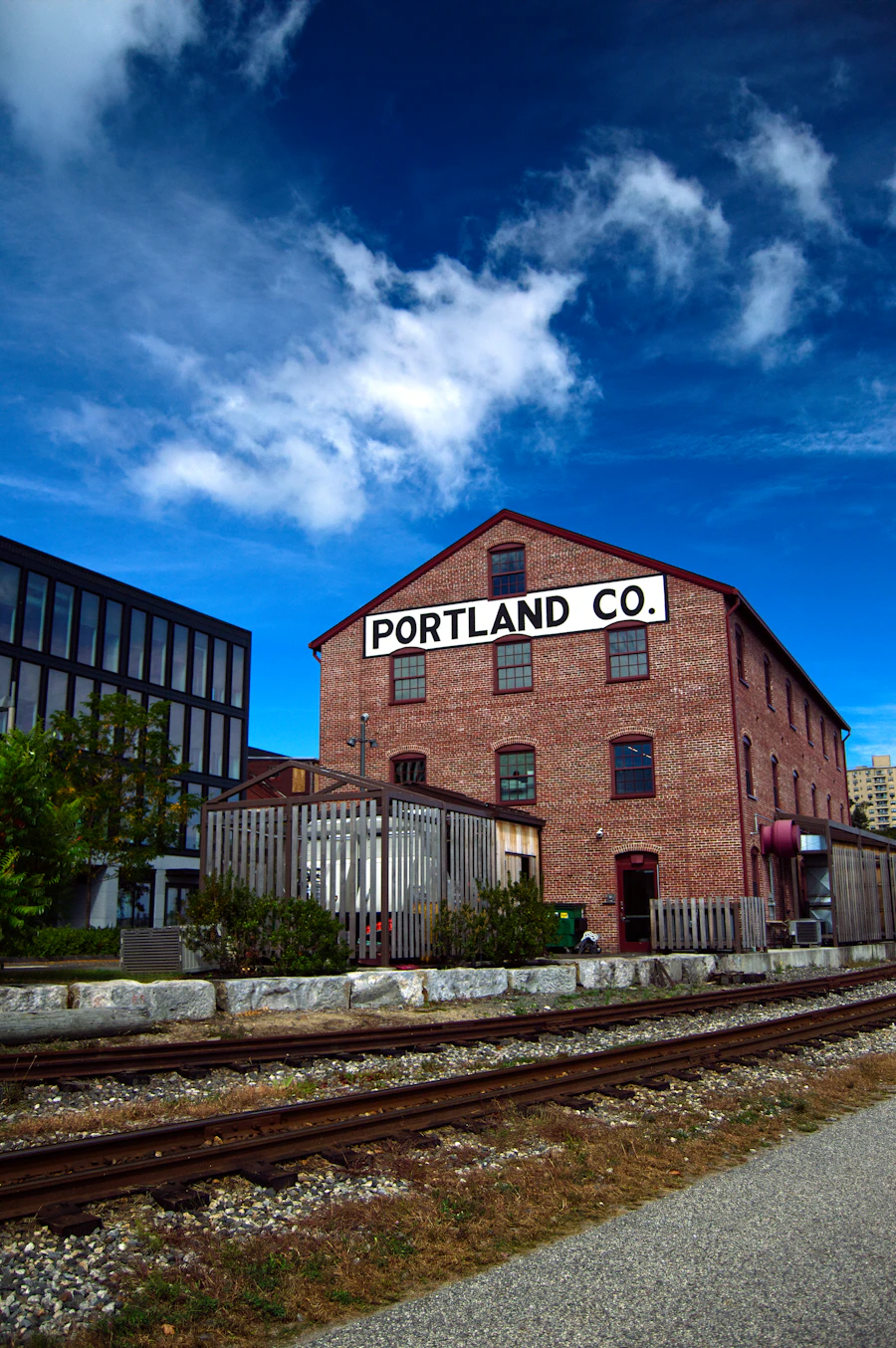 A brick building with a Portland Co. sign beside railroad tracks