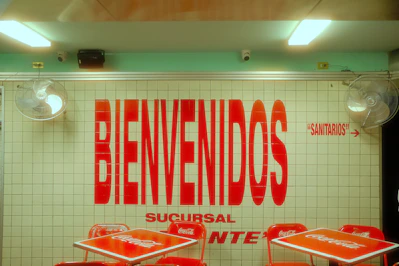 Red 'bienvenidos' sign above red tables and chairs