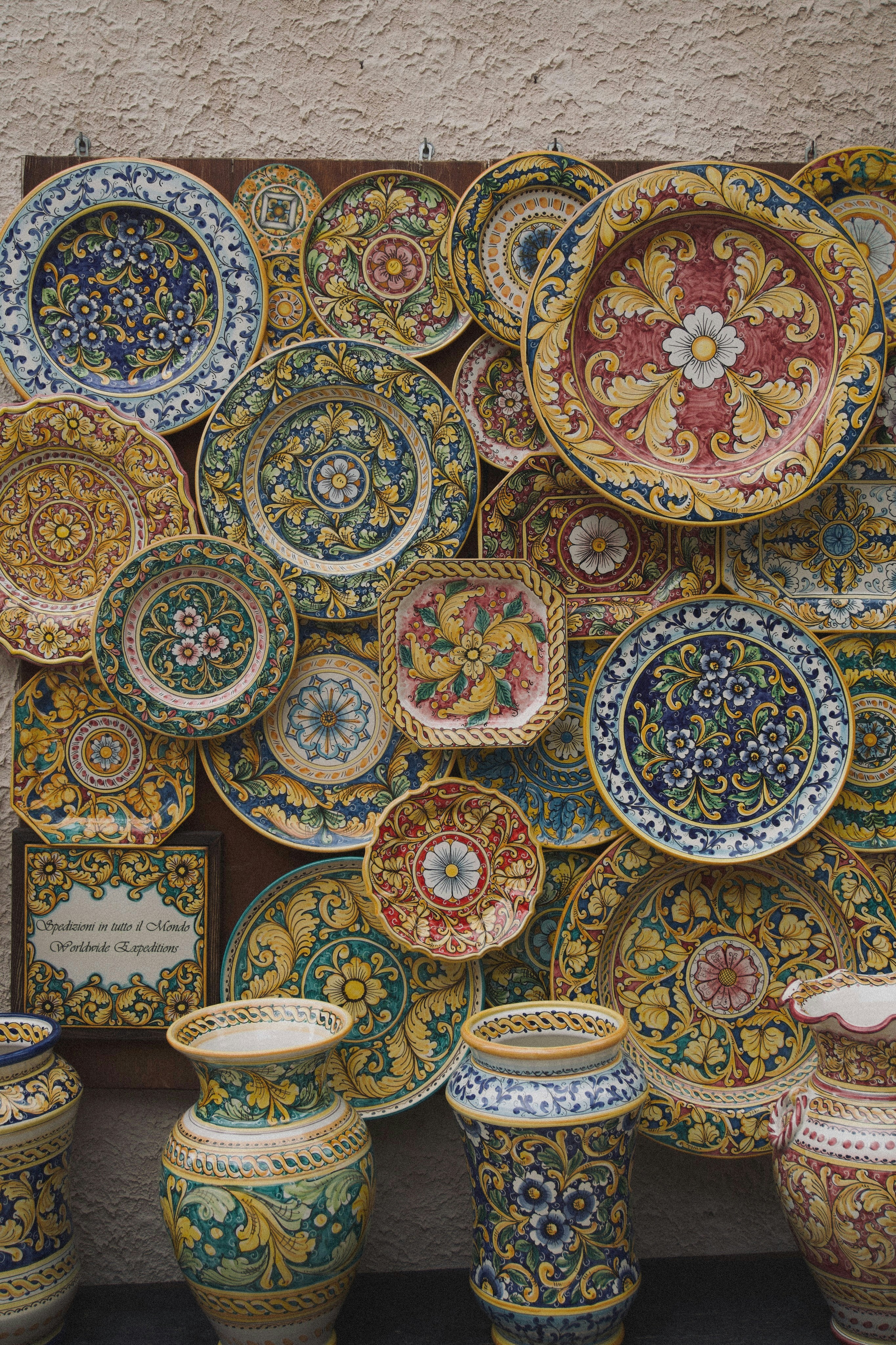 Hand-painted ceramic plates and vases hung as wall art